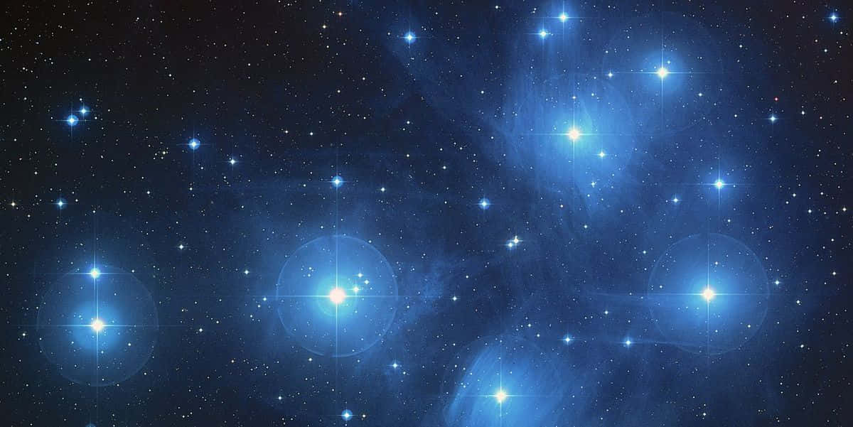 太空 桌布 壁紙 — 一個充滿發光藍色星星和星雲的宇宙空間，背景是深邃的黑色虛空。