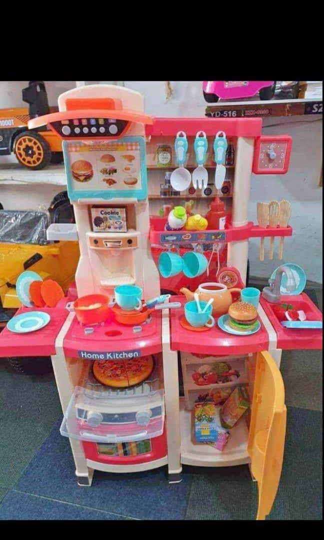 toys 桌布 壁紙 — 一個充滿色彩繽紛配件和假食物的鮮豔粉紅色塑膠玩具廚房套裝。
