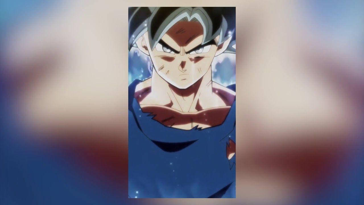 Ultra Instinct Goku 桌布 壁紙 — 一個兇猛的動漫戰士，有著尖刺頭髮和發光的眼睛，在宇宙藍色背景下強烈凝視。
