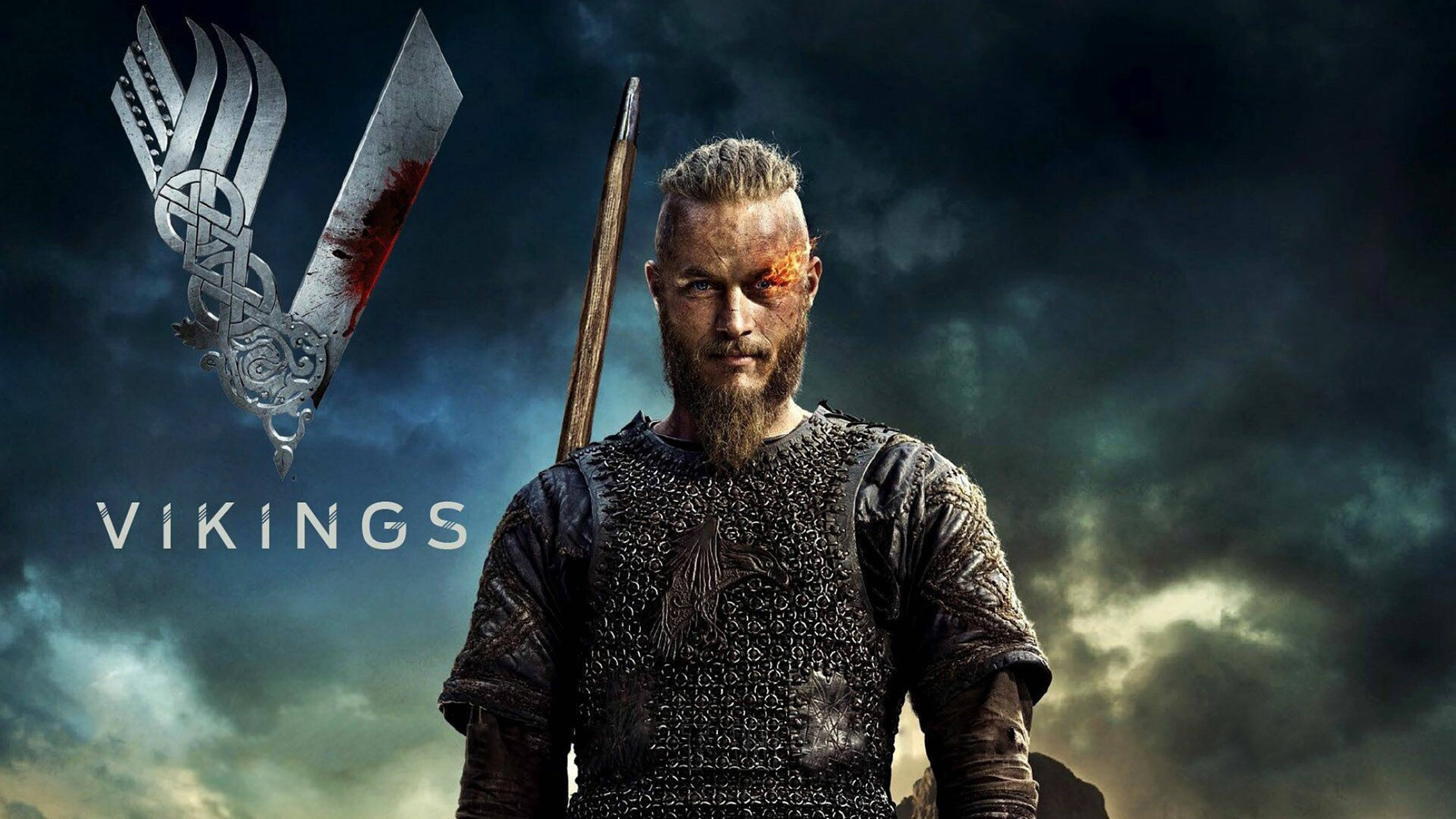 Vikings 桌布 壁紙 — 一個兇猛的維京戰士，手持染血的劍和華麗的盾牌，站在暴風雨的天空下。