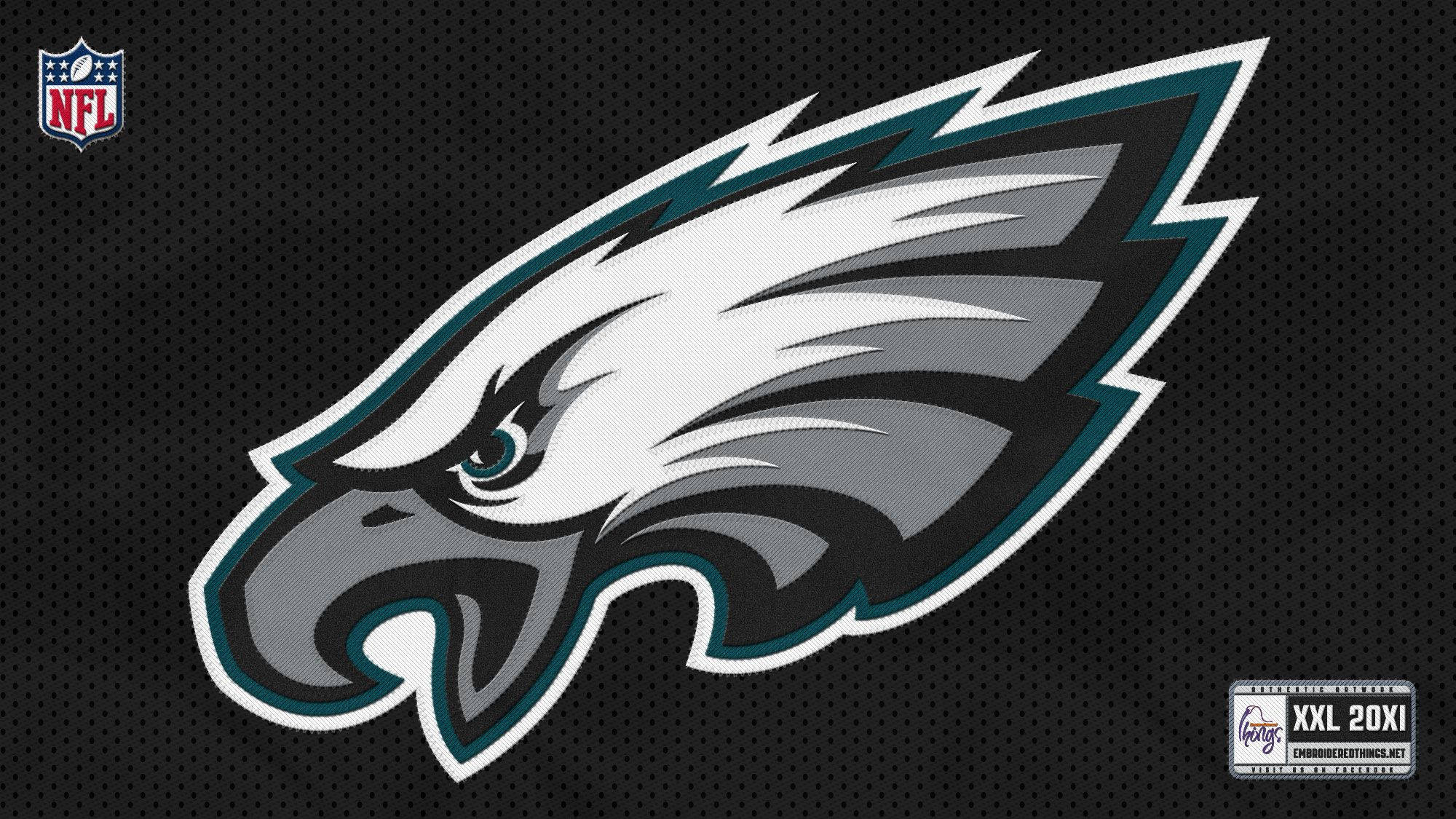 Eagles 桌布 壁紙 — 一個兇猛的鷹標誌，帶有尖銳的白色、灰色和藍綠色羽毛，置於黑色網格背景上。