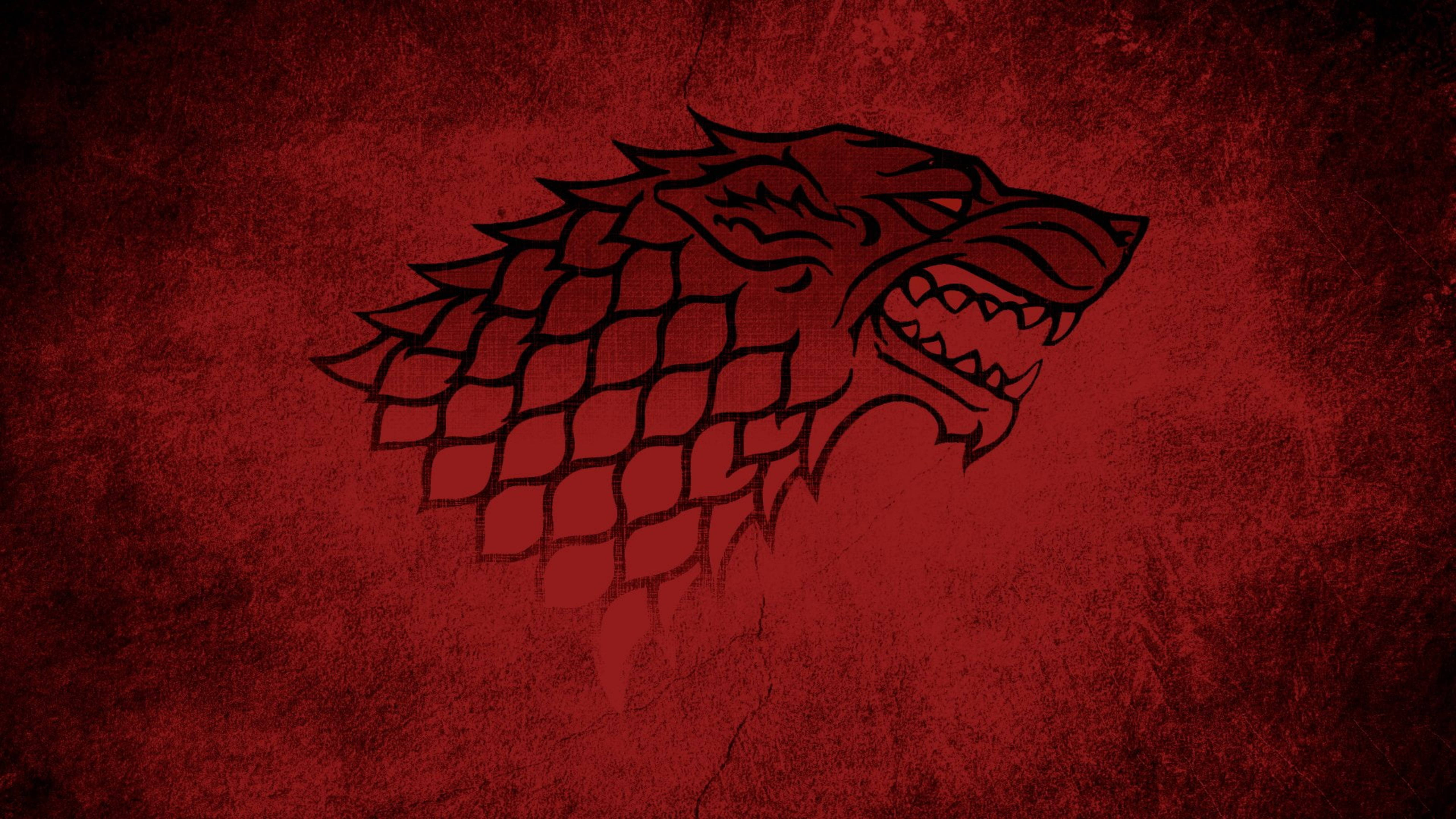 House Stark 桌布 壁紙 — 一個兇猛的黑冰原狼頭徽章，帶有鱗片狀的脖子，在紋理深紅色背景上脫穎而出。