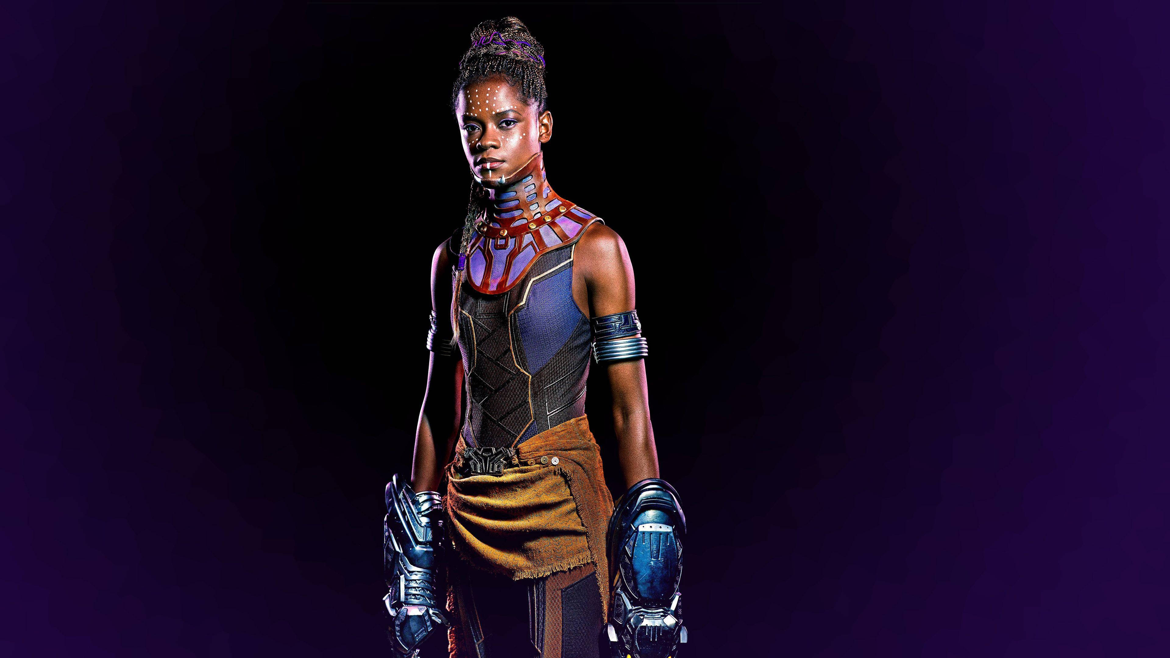 Shuri 桌布 壁紙 — 一個兇猛的黑豹角色在深紫色工作室中擺好姿勢，身穿發光盔甲和複雜的臉部彩繪。