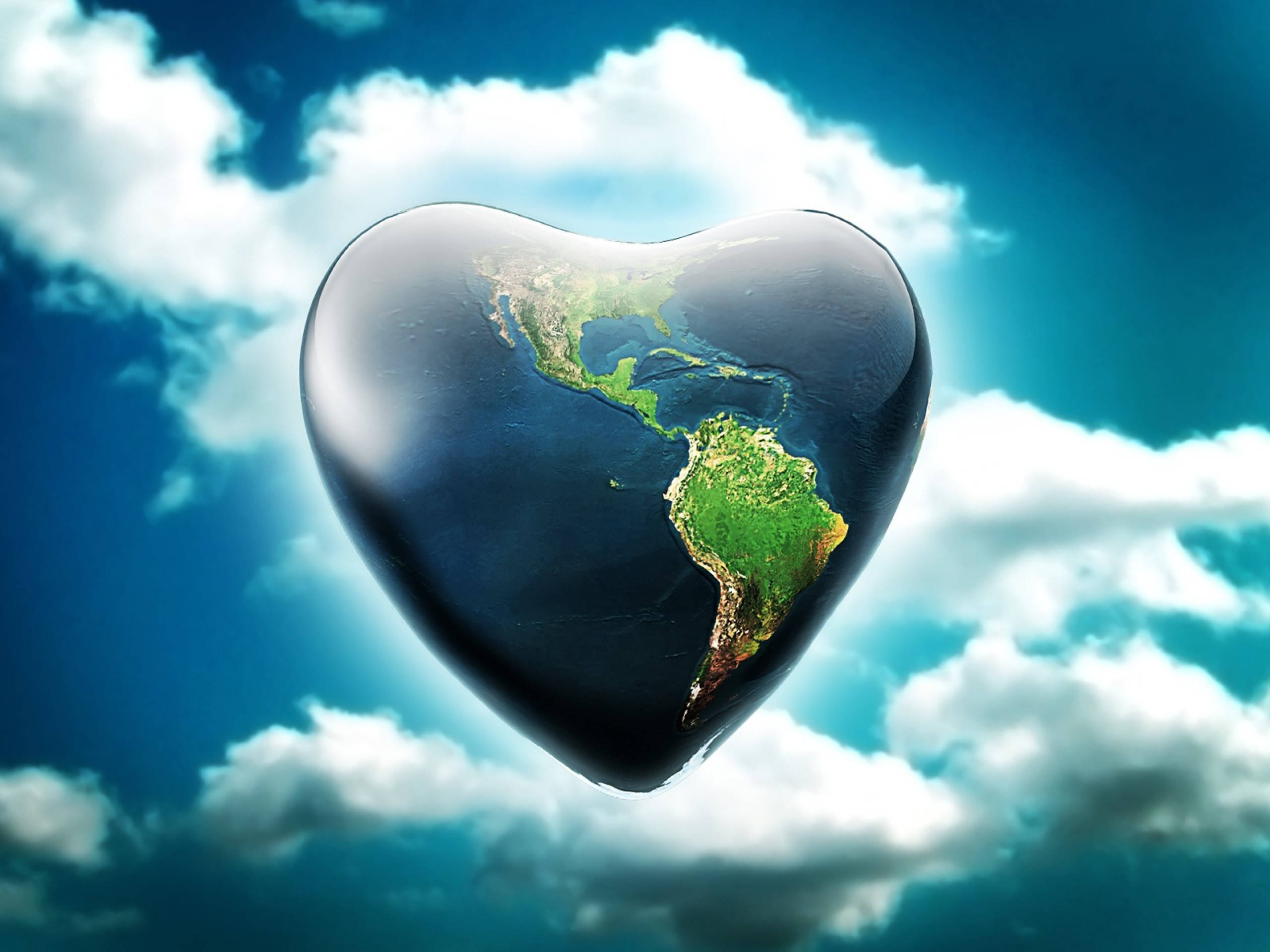 Earth Day 桌布 壁紙 — 一個光滑的心形地球在點綴著蓬鬆白雲的鮮豔藍天中寧靜地漂浮。
