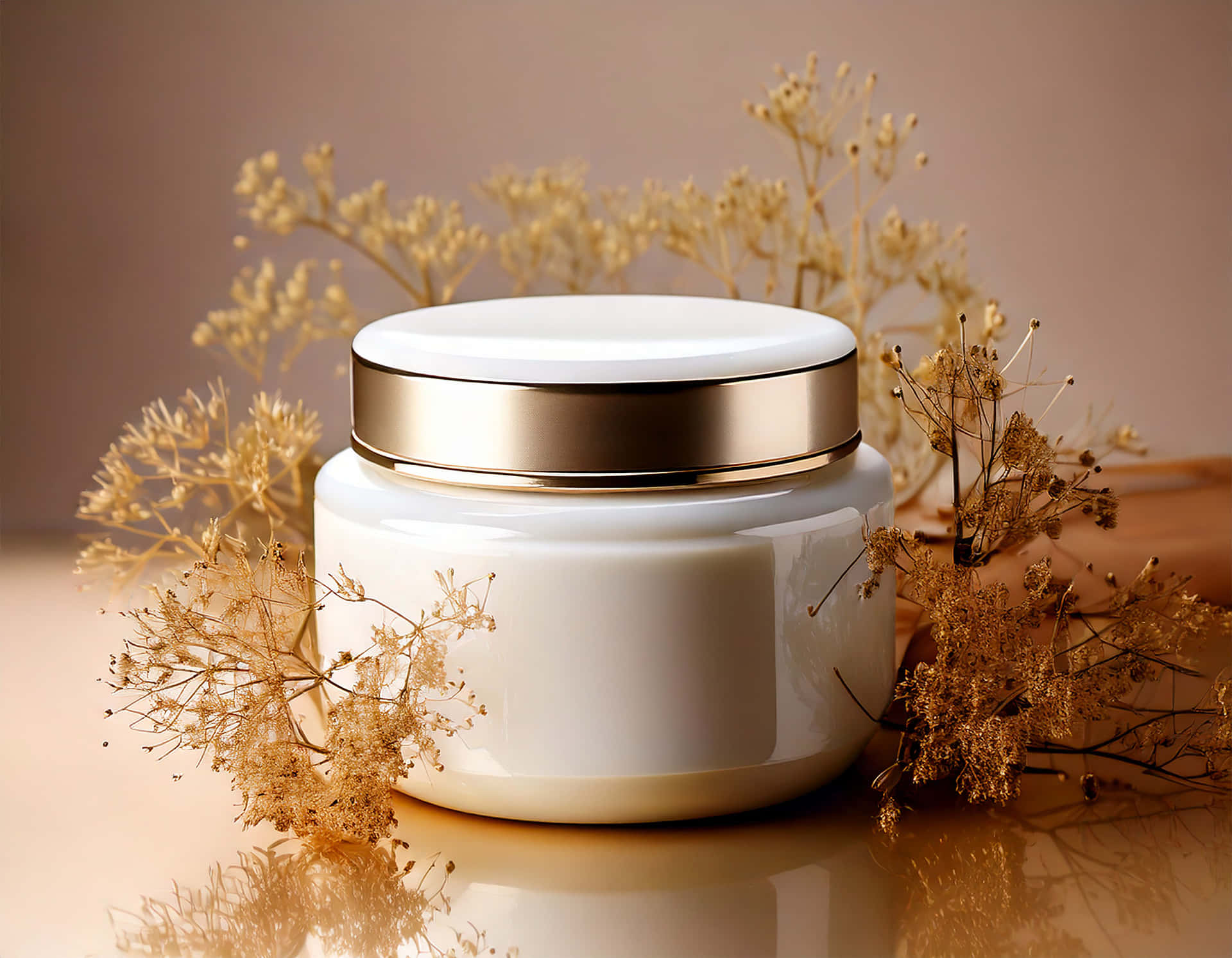 An elegant white cosmetic jar 壁紙 — 一個光滑的白色罐子配金色蓋子，周圍環繞著乾燥的金色花朵，放置在反光表面上。