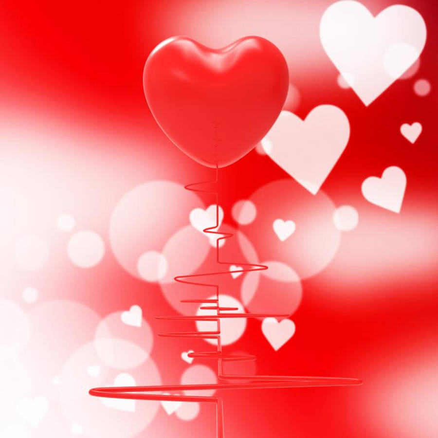 Heartbeat 桌布 壁紙 — 一個光滑的紅色心形氣球漂浮在心跳線上方，背景是充滿活力的紅色和白色散景，還有漂浮的心形。