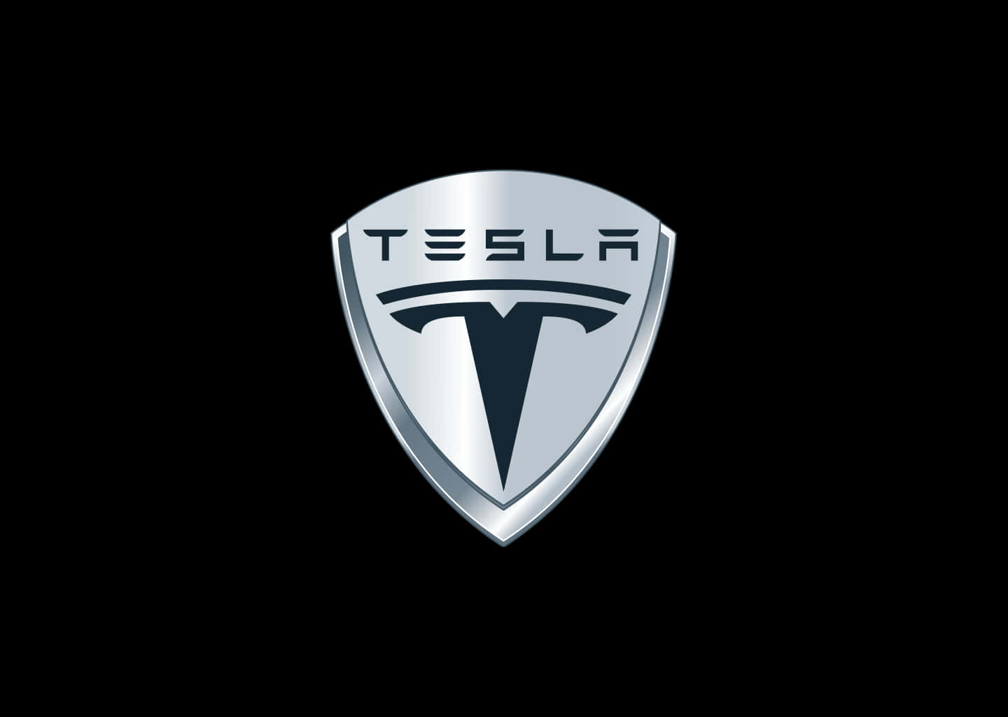 桌布 壁紙 — 一個光滑的銀色 Tesla 標誌盾牌徽章，居中於帶有金屬光澤的純黑色背景上。