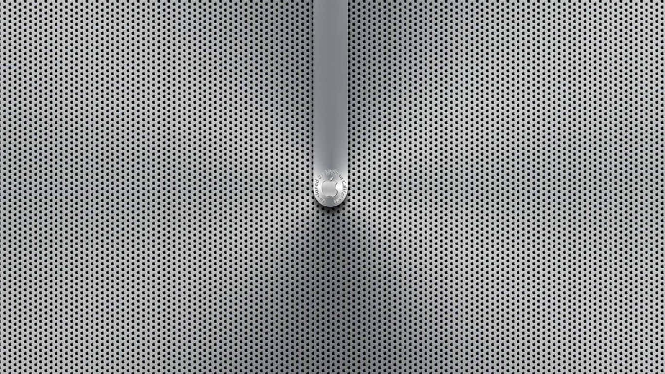 Aluminium 桌布 壁紙 — 一個光滑的銀色把手，帶有圓形標誌，從穿孔金屬表面伸出，在柔和的光線下。
