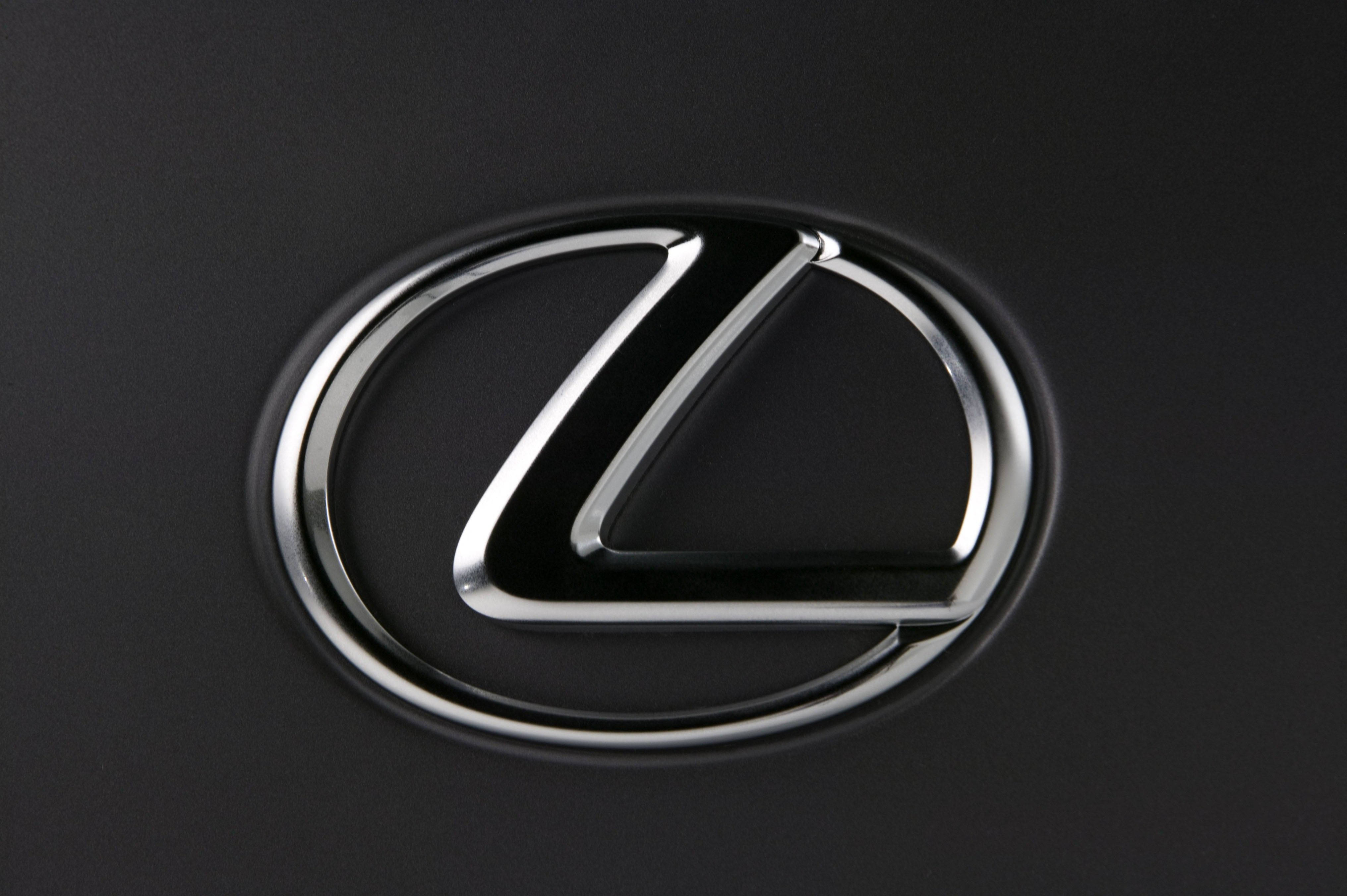 Lexus 標誌 桌布 壁紙 — 一個光滑的鍍鉻凌志標誌在啞光黑色汽車表面上閃耀的特寫。