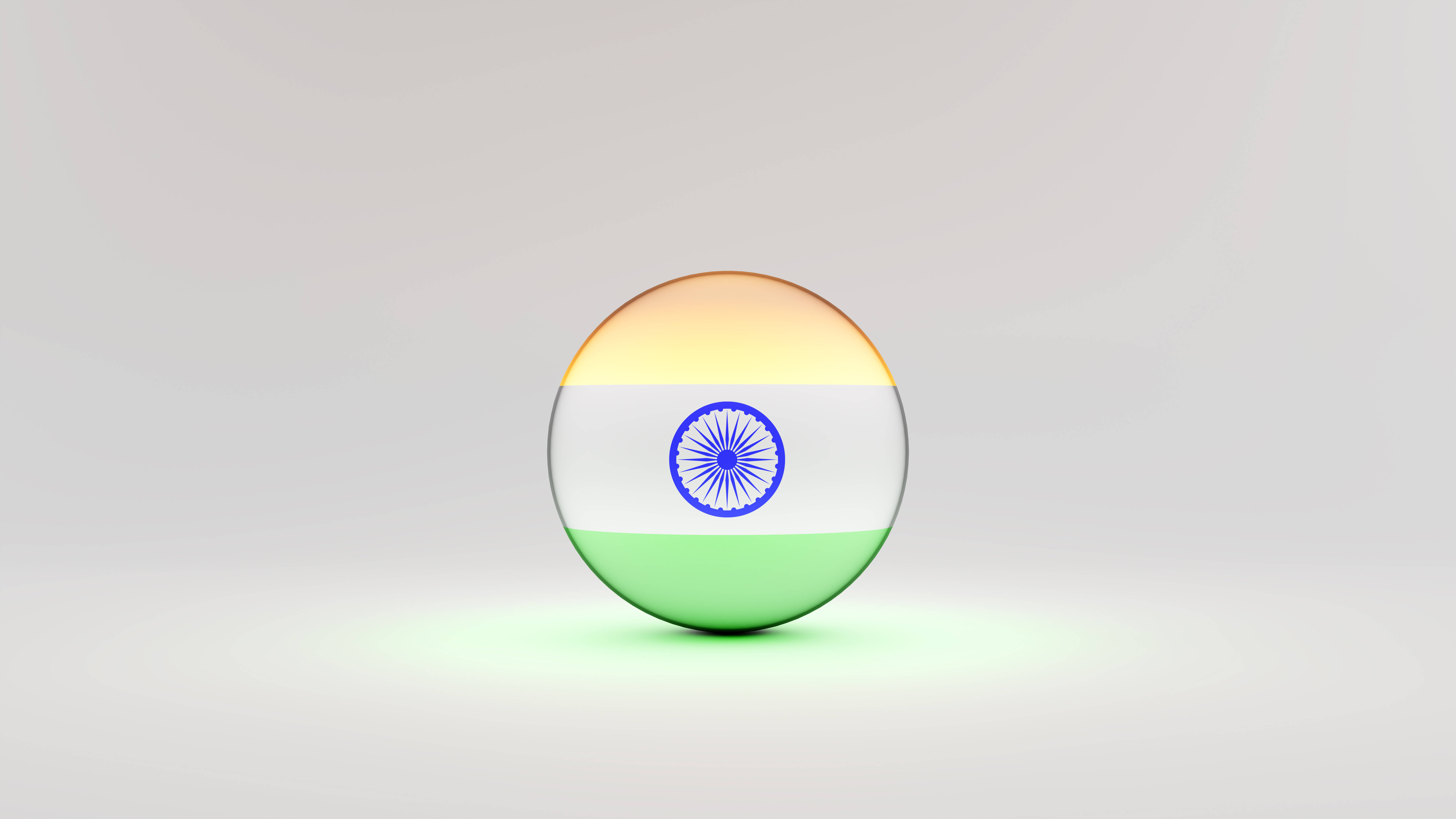 Tiranga 桌布 壁紙 — 一個光澤球體，在中性工作室背景上展示帶有阿育王法輪的印度三色旗。