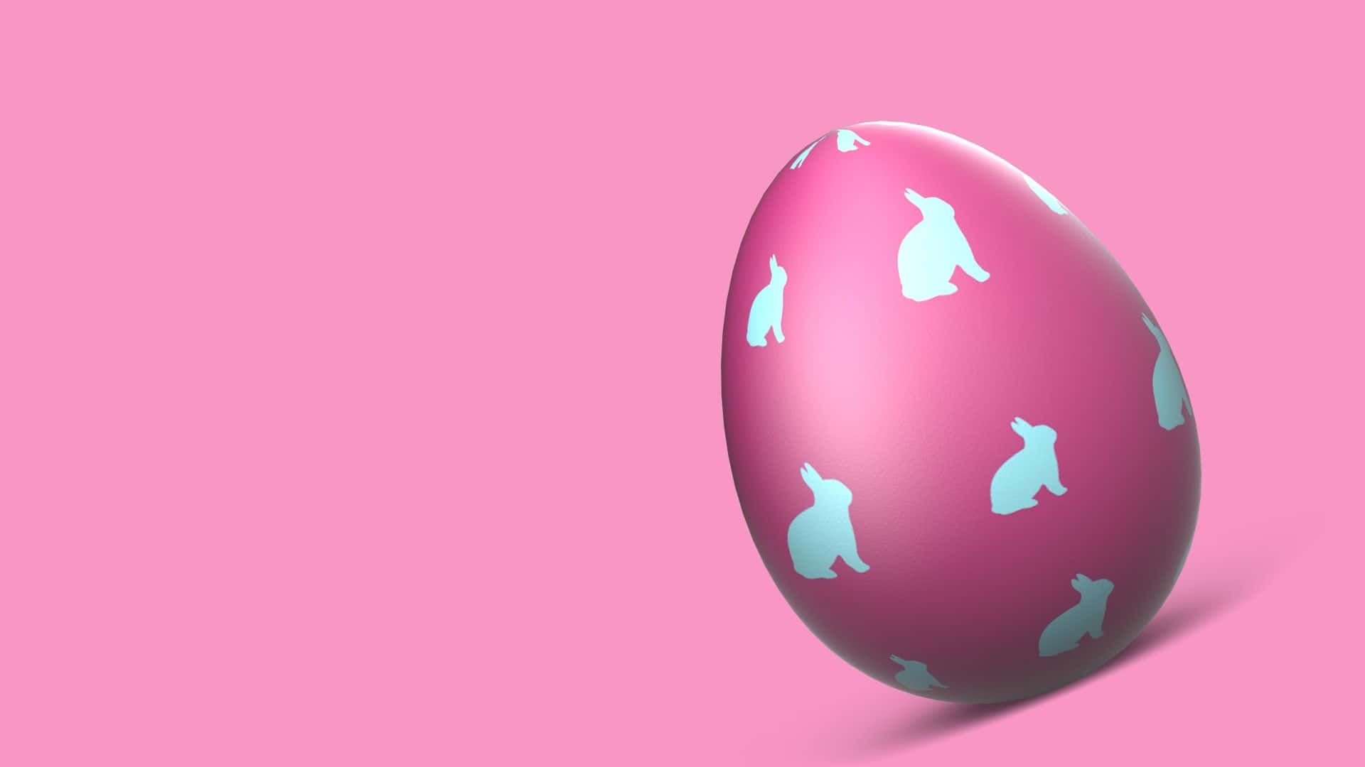 Easter Egg 桌布 壁紙 — 一個光澤的粉紅色復活節蛋，飾有淺藍色兔子剪影，放在純粉紅色背景上。