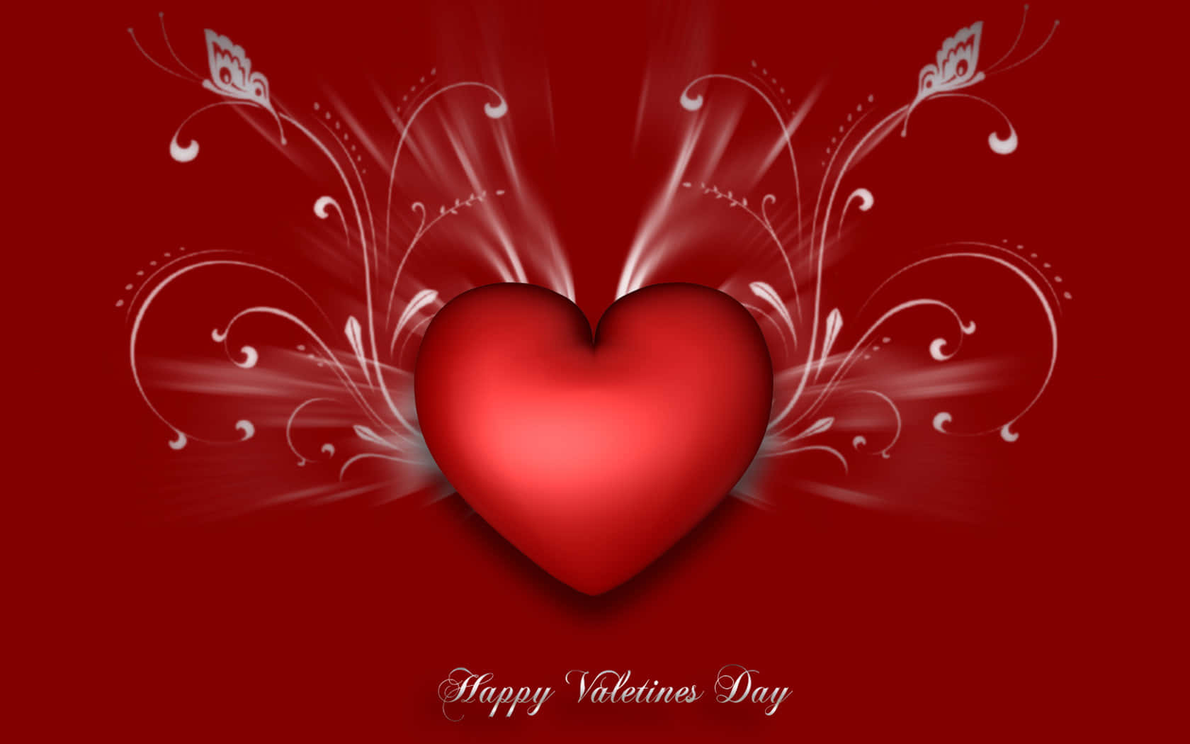High Resolution Valentines Day 桌布 壁紙 — 一個光澤的紅色心形在深紅色背景上散發出白色華麗漩渦，下方寫有「Happy Valentines Day」。