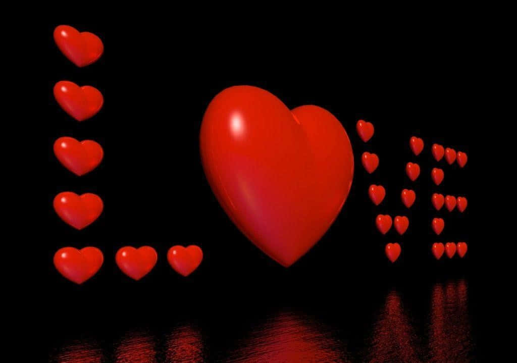 Cute Love Heart 桌布 壁紙 — 一個光澤的紅色心形拼出 'love'，並有較小的愛心排列在反光的黑色表面上。