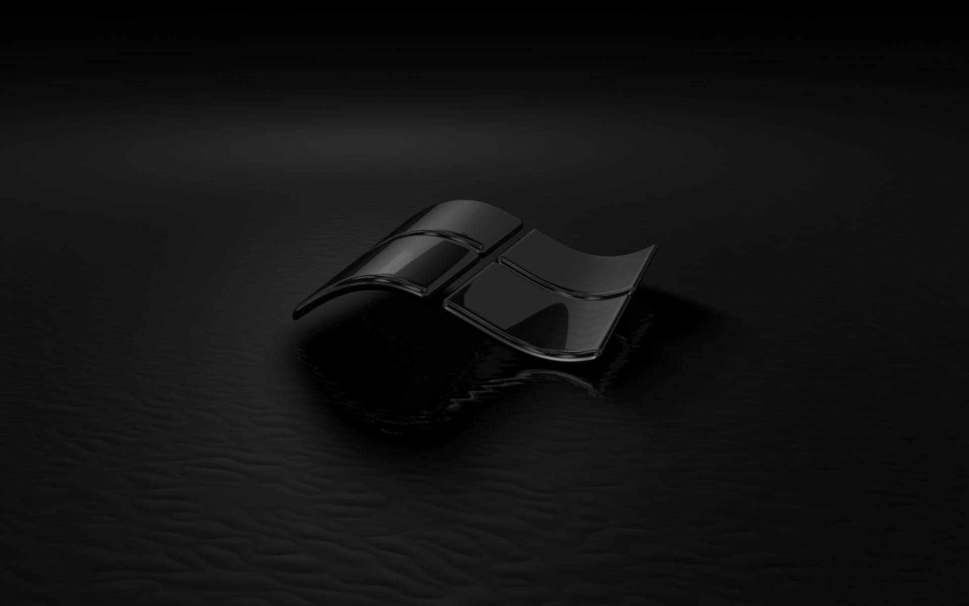 Dark Windows 桌布 壁紙 — 一個光澤的黑色Windows標誌放置在紋理深色表面上，在戲劇性的聚光燈下。