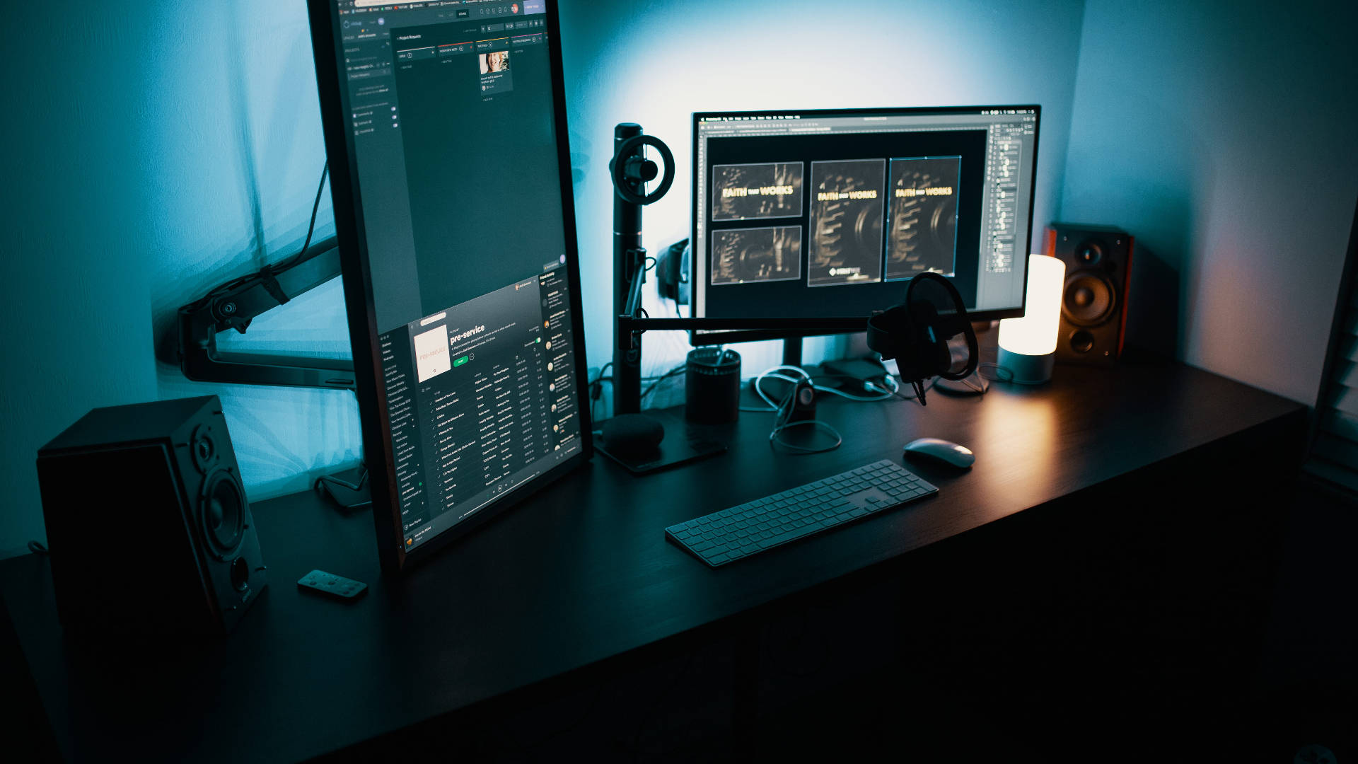 Working From Home 桌布 壁紙 — 一個光線昏暗的家庭工作室書桌，被多個顯示影片編輯軟體的顯示器發出的冷藍光籠罩。