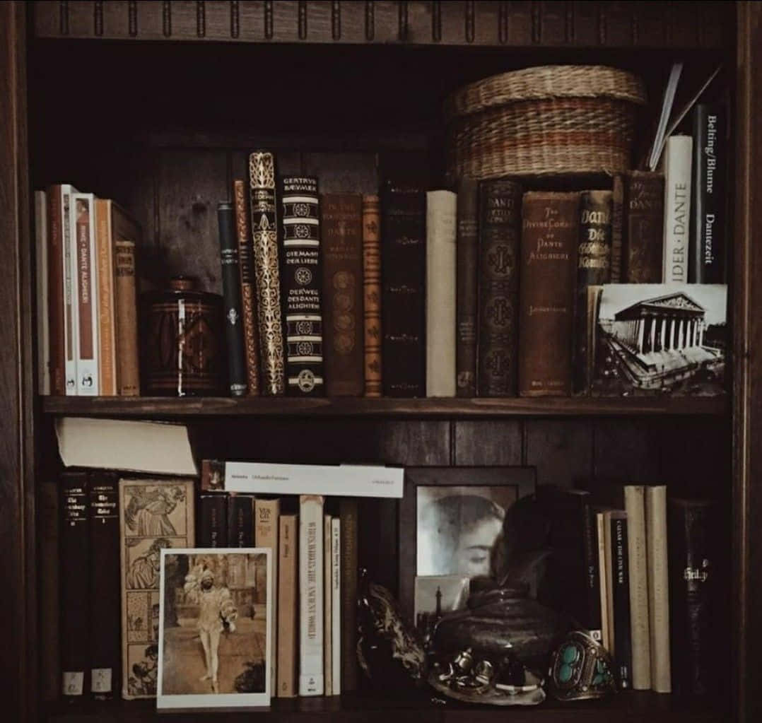 Dark Academia Aesthetic 桌布 壁紙 — 一個光線昏暗的木書架，放滿復古書籍、照片和裝飾品，營造出舒適的知性氛圍。