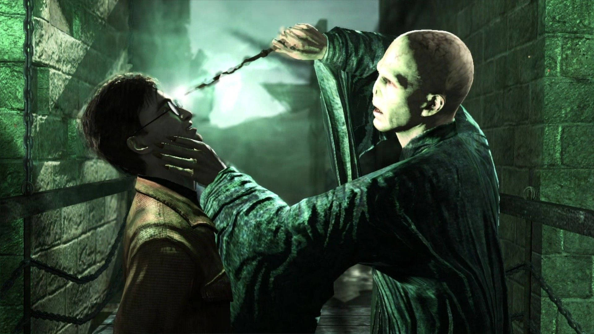 voldemort 桌布 壁紙 — 一個光頭、身穿黑袍的可怕人物，在骯髒的石頭地牢中，用發光的魔杖抵住一名年輕男子的喉嚨。