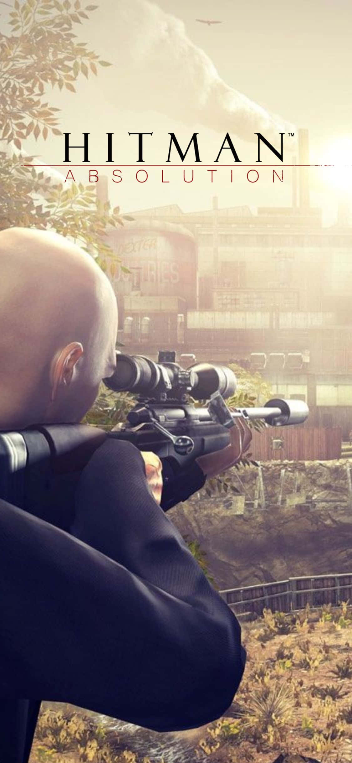 iPhone X Hitman Absolution 桌布 壁紙 — 一個光頭刺客穿著黑色西裝，從一個俯瞰陽光照耀的工業城鎮的山坡上瞄準狙擊步槍。