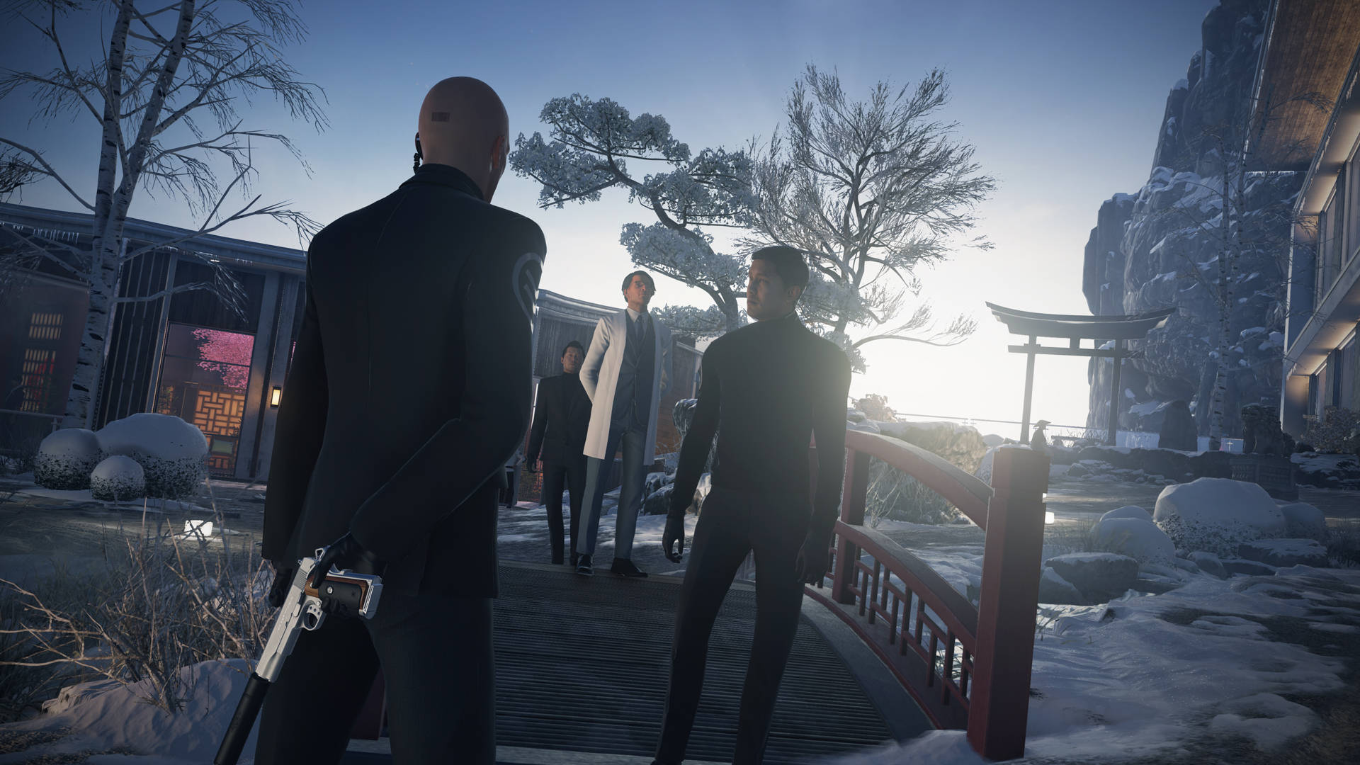 hitman absolution HD 桌布 壁紙 — 一個光頭刺客身穿黑色西裝，在黎明時分走過一座積雪的日本橋，走向鳥居附近的一群男人。