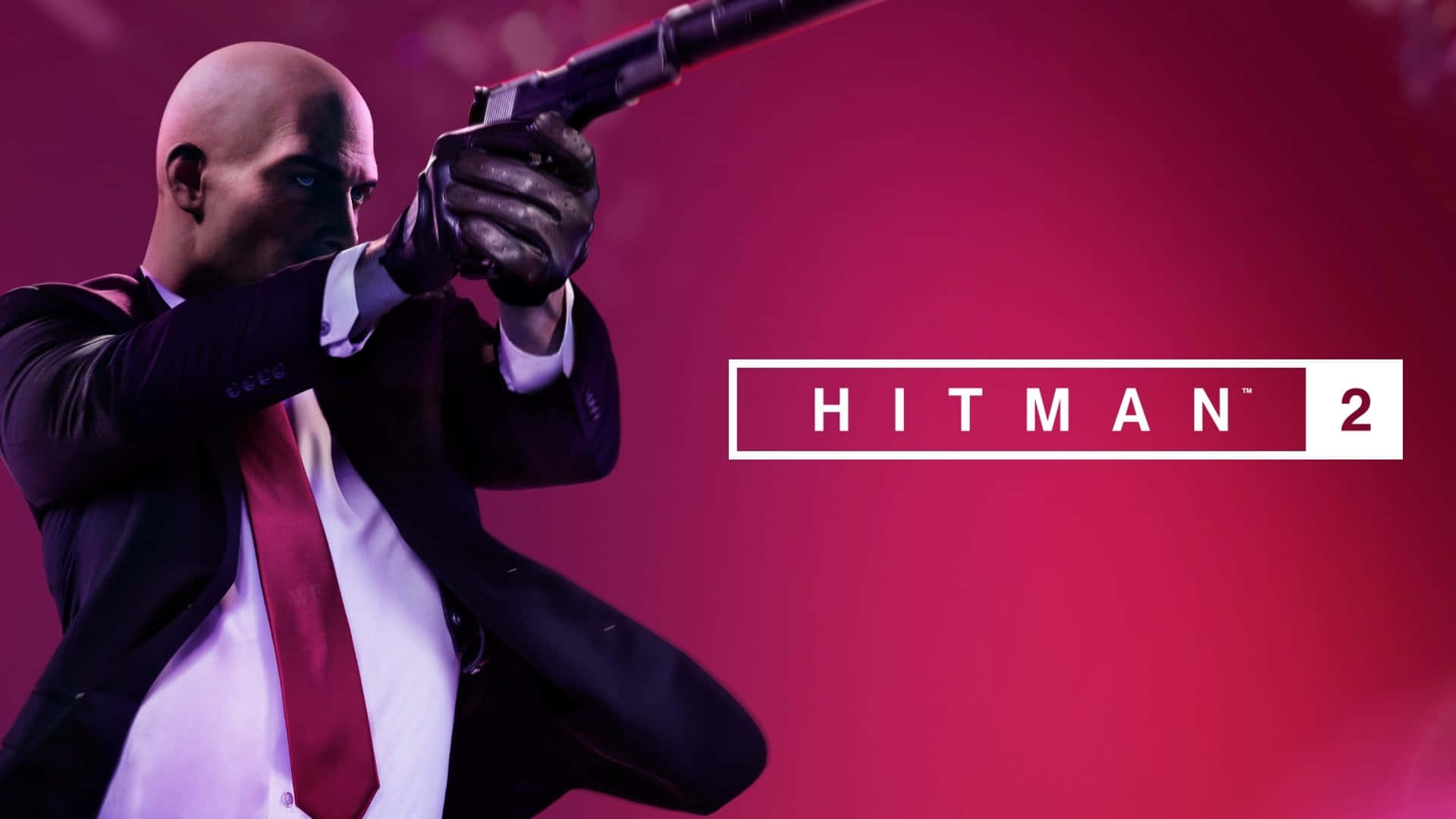 Hitman 2 桌布 壁紙 — 一個光頭殺手身穿西裝，瞄準一把散彈槍，背景是鮮豔的洋紅色，並帶有Hitman 2標誌。