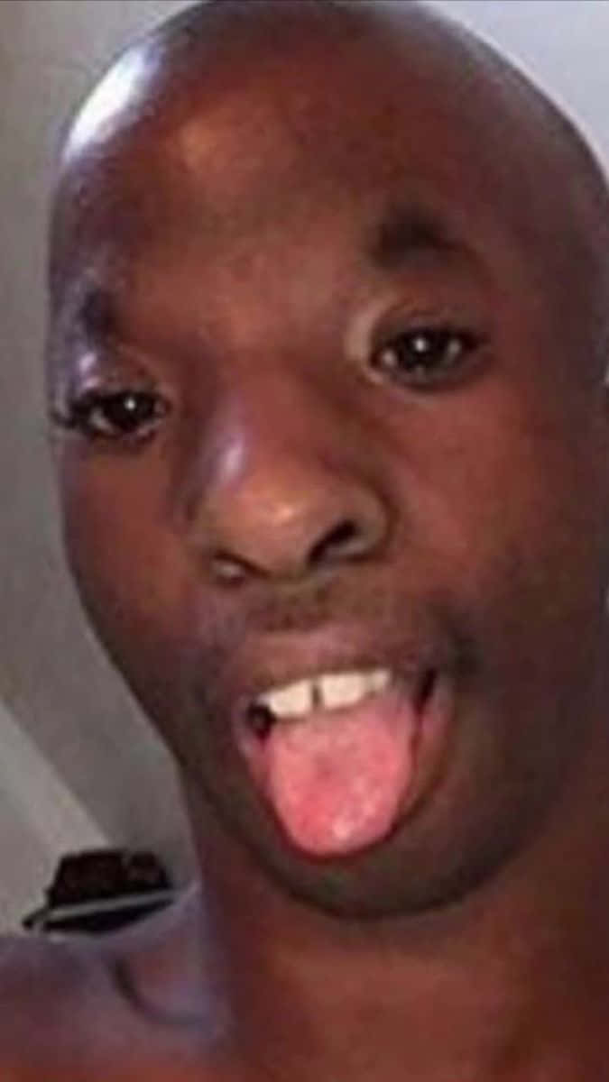 meme 桌布 壁紙 — 一個光頭男人伸出舌頭、表情頑皮的近距離照片。