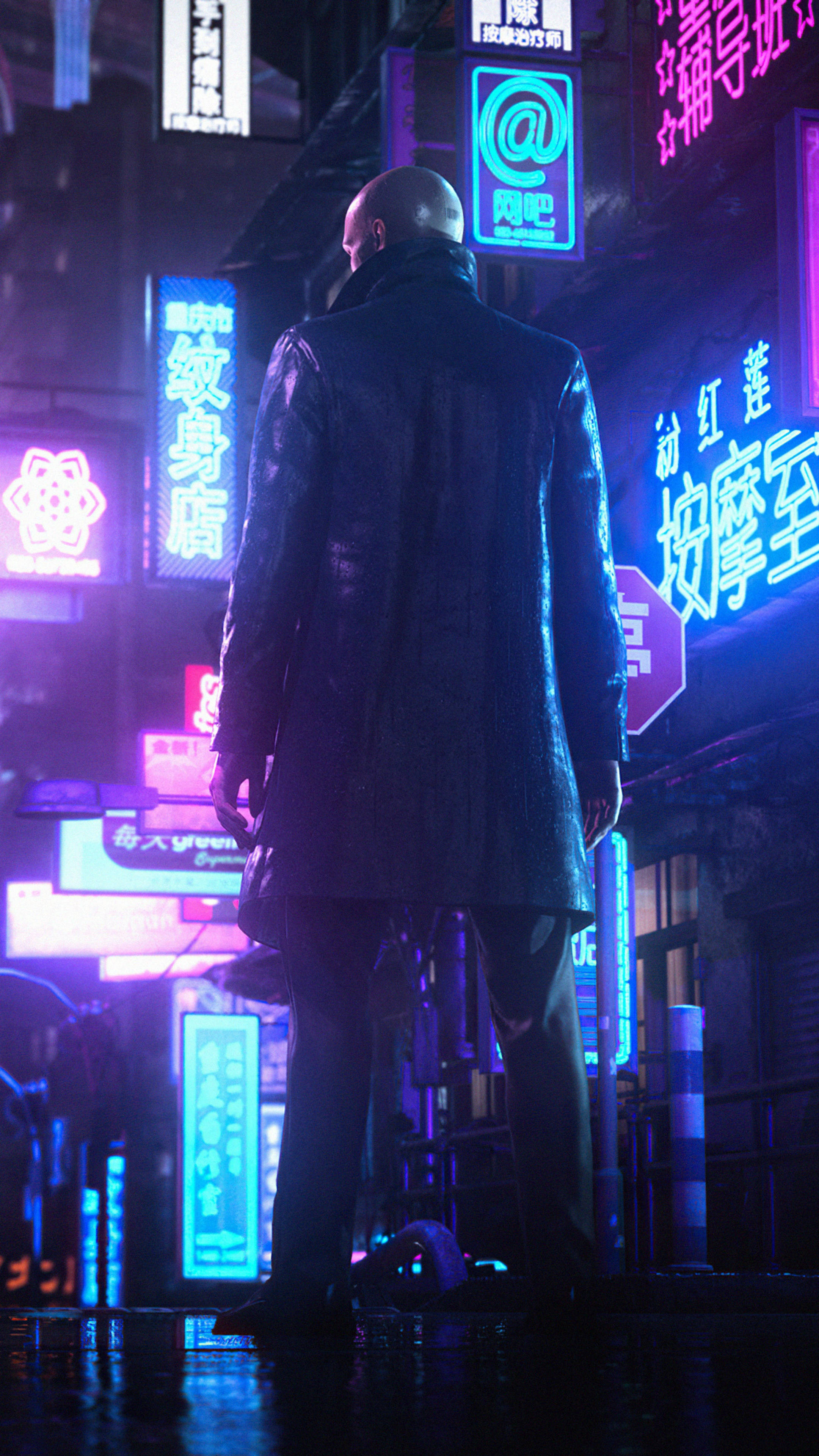 Hitman Phone 桌布 壁紙 — 一個光頭男人穿著深色外套，夜晚獨自站在被雨水打濕的霓虹燈街道上，周圍是發光的中文招牌。