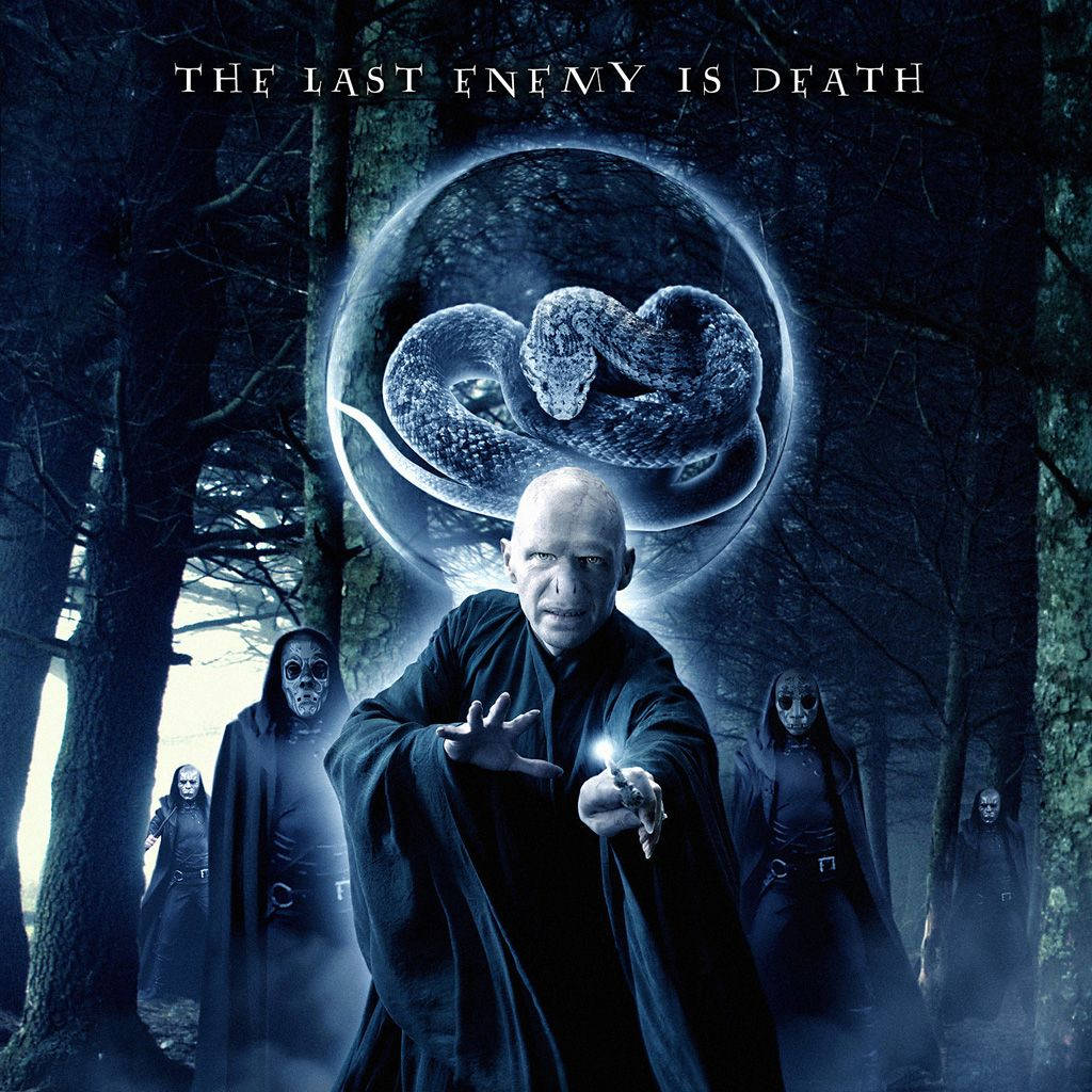 voldemort 桌布 壁紙 — 一個光頭男人穿著深色長袍，在陰暗的森林中施法，一個發光的球體盤繞著一條蛇，懸浮在他上方。