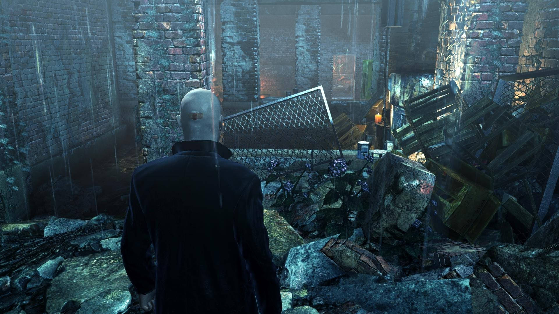 hitman absolution HD 桌布 壁紙 — 一個光頭男人穿著黑色外套，站在被雨水浸透的廢墟小巷中，周圍有破碎的磚牆和散落的碎片。