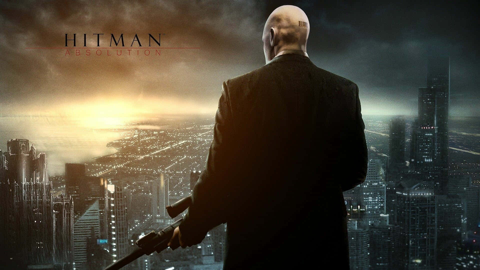 1920x1080 Hitman 2 桌布 壁紙 — 一個光頭男人穿著黑色西裝，在黃昏時分俯瞰廣闊的城市天際線，手持消音手槍。