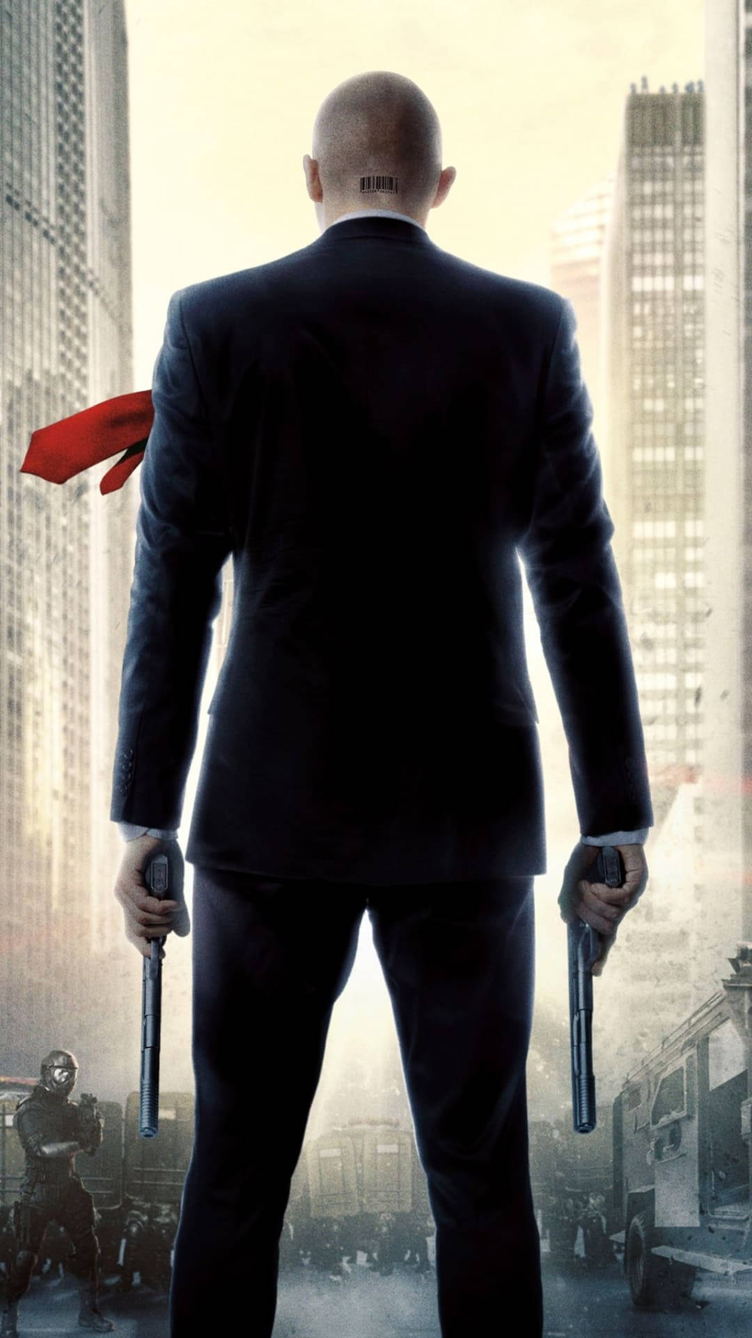 Hitman Phone 桌布 壁紙 — 一個光頭男人穿著黑色西裝，站在城市街道上，手持兩把槍，身後有一條紅色圍巾飄揚。