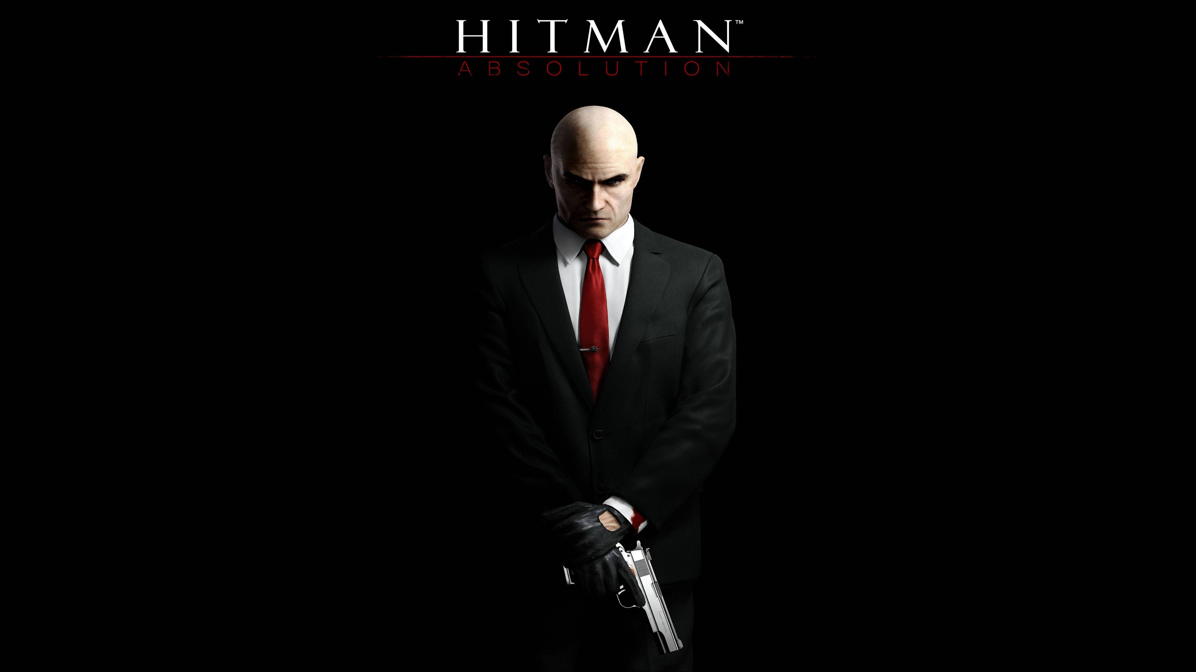 Hitman Absolution 桌布 壁紙 — 一個光頭男人穿著黑色西裝和紅色領帶，手持銀色手槍，背景為純黑色，上方有「Hitman Absolution」文字。
