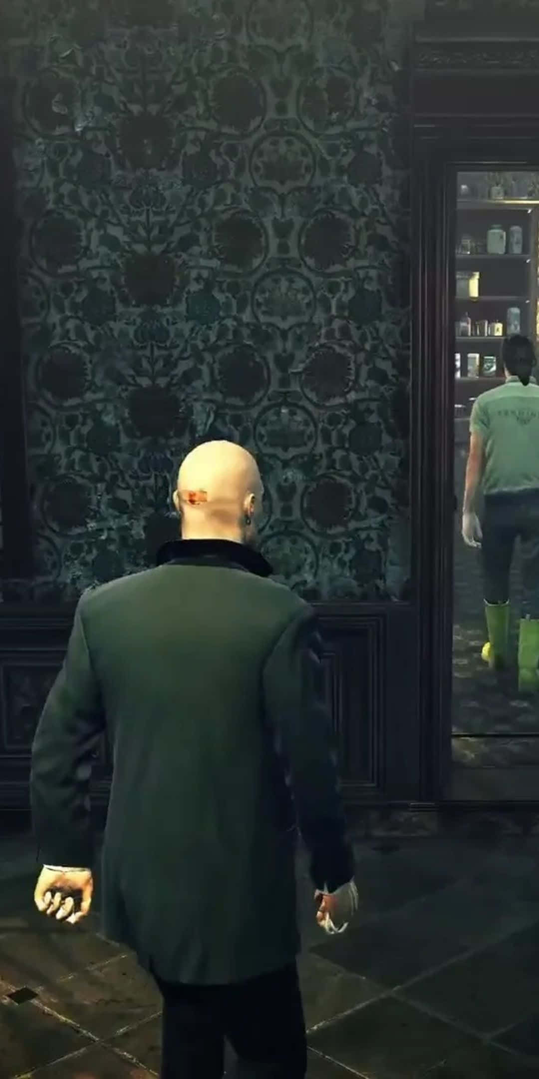 Pixel 3 Hitman Absolution 桌布 壁紙 — 一個光頭男子穿著深色西裝，走過一個燈光昏暗的房間，房間裡有華麗的綠色壁紙和一扇玻璃門，玻璃門後顯露出另一個人。