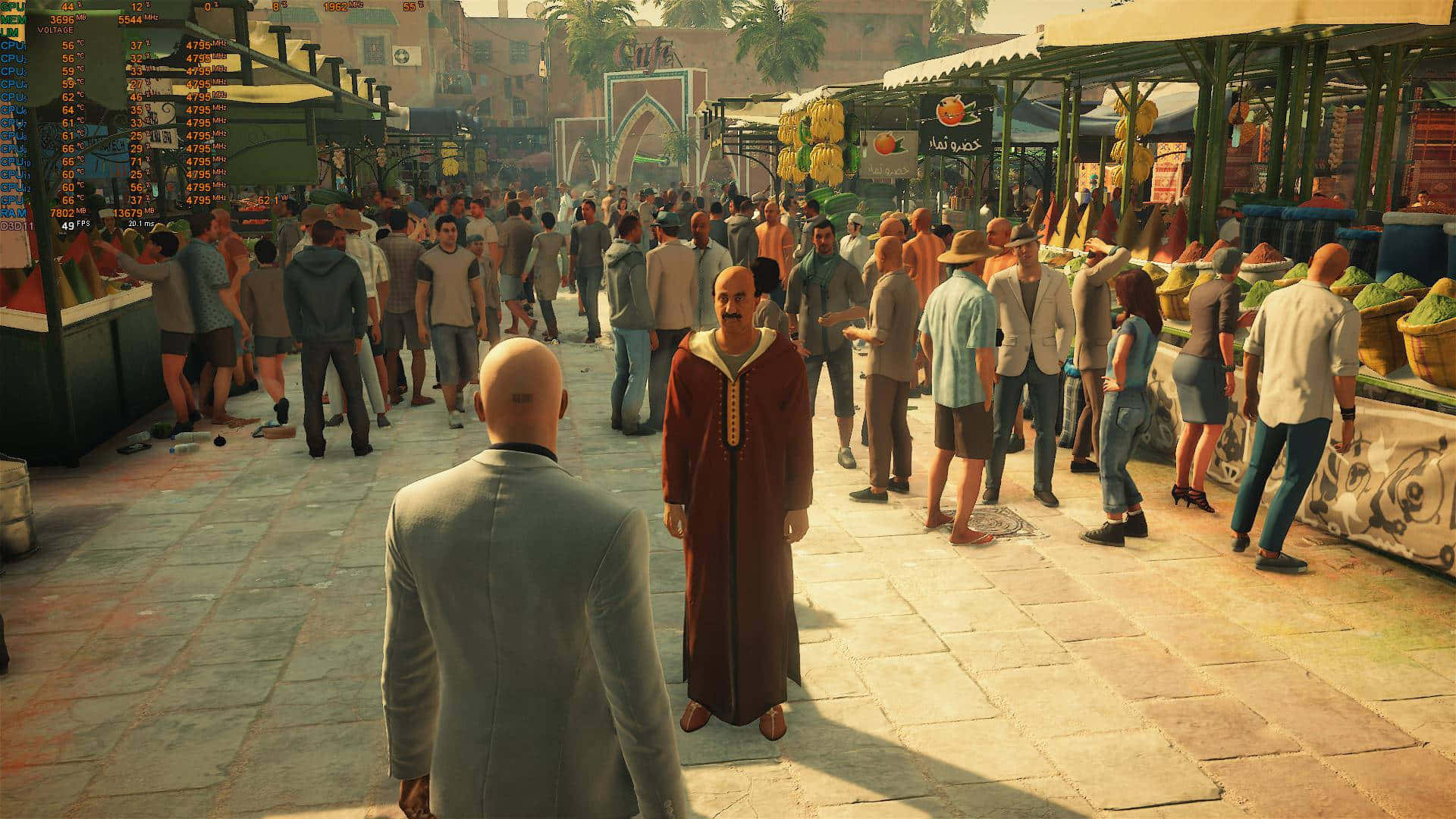 1920x1080 Hitman 2 桌布 壁紙 — 一個光頭男子穿著灰色西裝，在溫暖的金色陽光下，穿過一個充滿商販和購物者的繁忙中東市場。