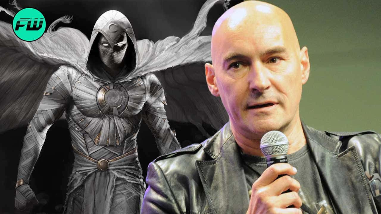 Grant Morrison 桌布 壁紙 — 一個光頭男子穿著皮夾克，在一個灰階插圖的翼面蒙面超級英雄旁邊對著麥克風說話。