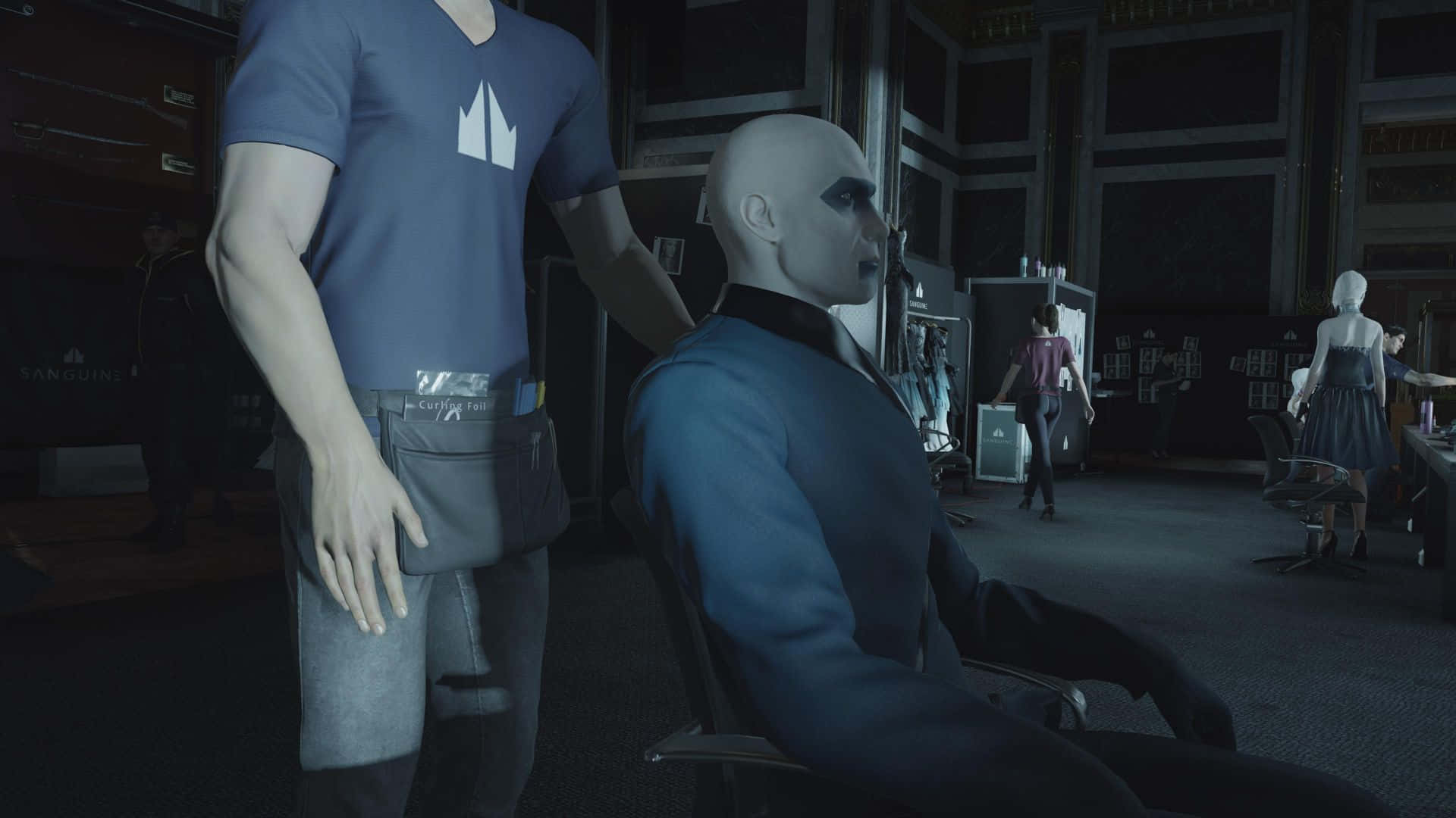 Hitman Agent 47 桌布 壁紙 — 一個光頭男子穿著藍色西裝坐在燈光昏暗的房間裡，另一個穿著藍色襯衫的男子表情嚴肅地站在他旁邊。