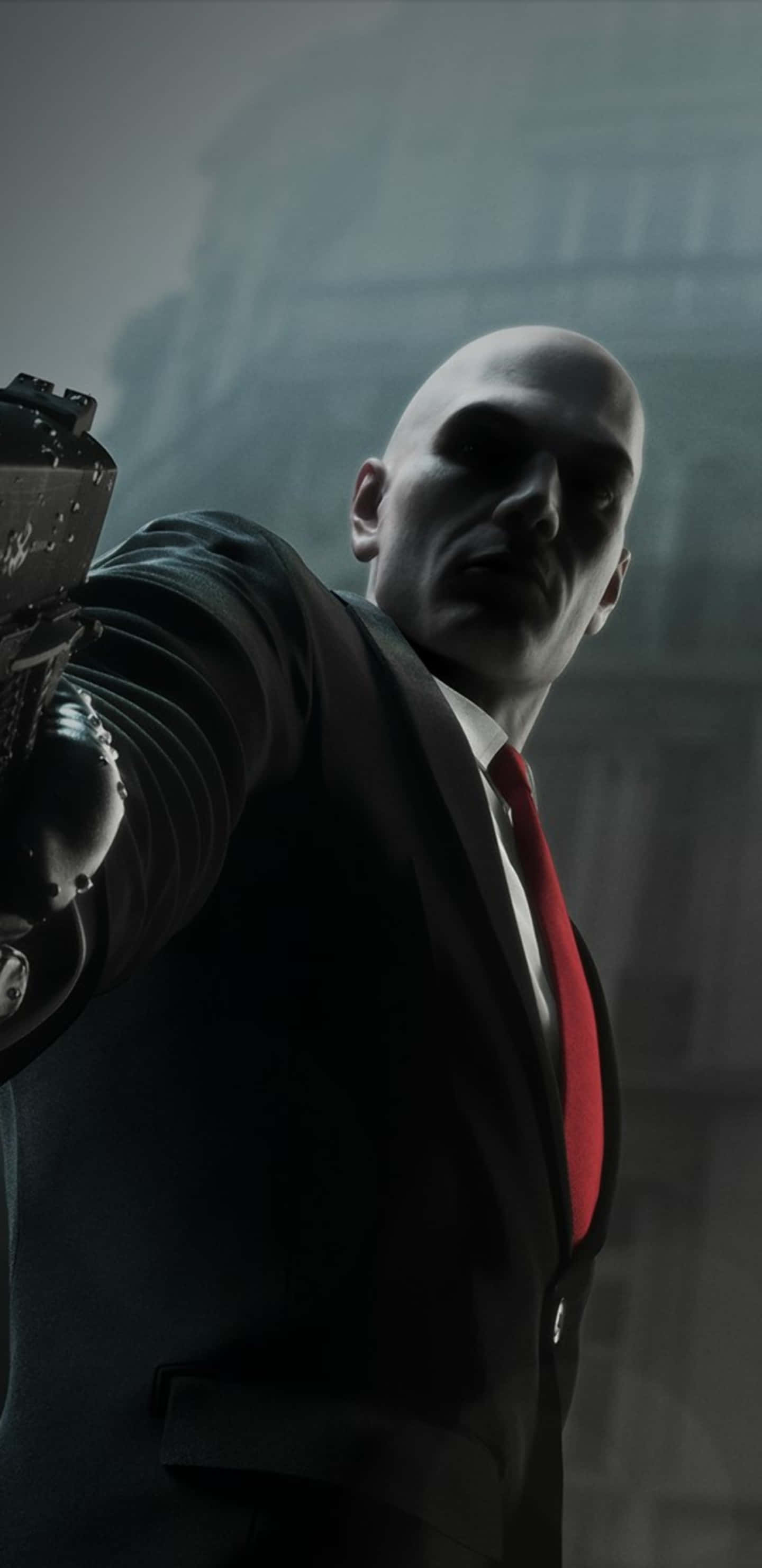 Pixel 3xl Hitman 桌布 壁紙 — 一個光頭男子身穿深色西裝和紅色領帶，在模糊的城市背景下，表情陰沉地向前瞄準手槍。