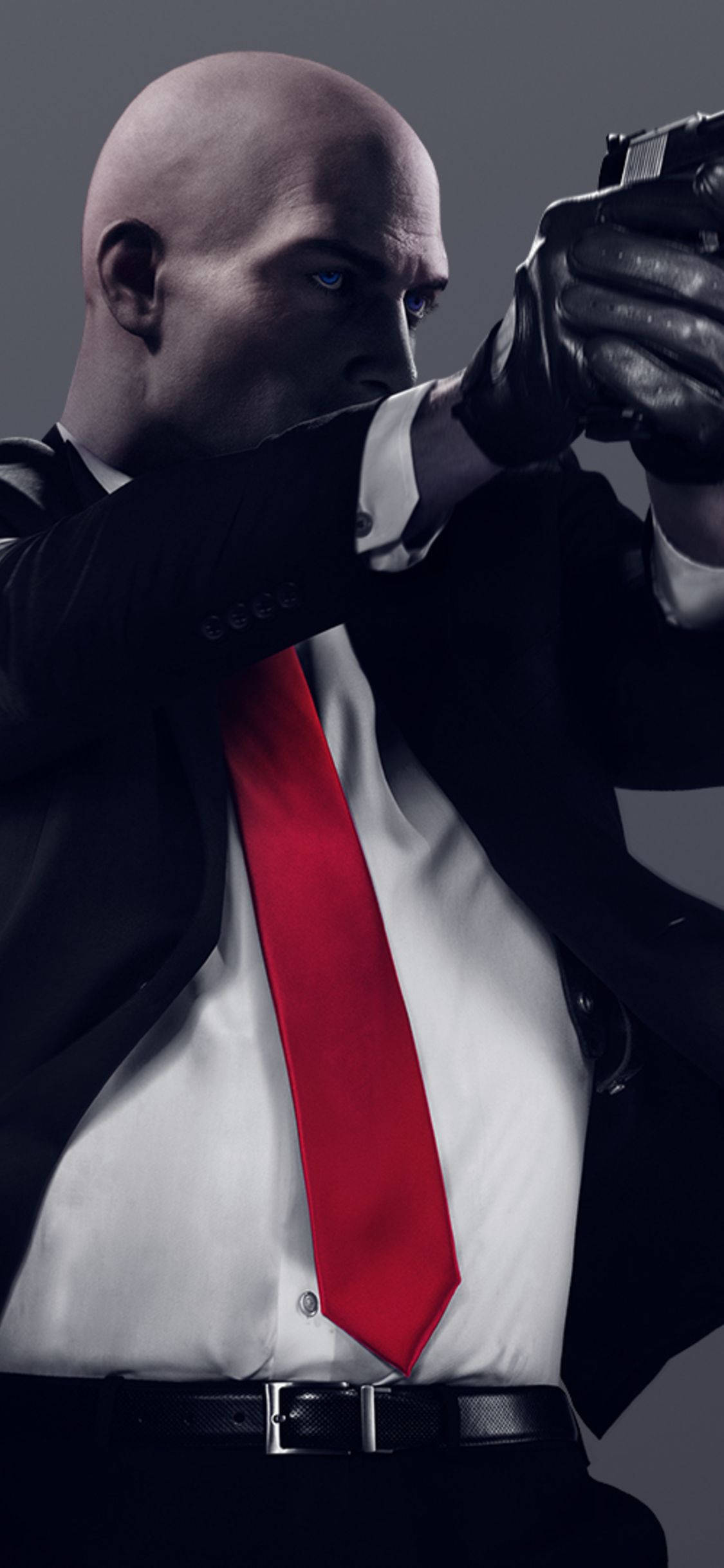 hitman iPhone 桌布 壁紙 — 一個光頭男子身穿黑色西裝和紅色領帶，在灰色背景前專注地瞄準手槍。