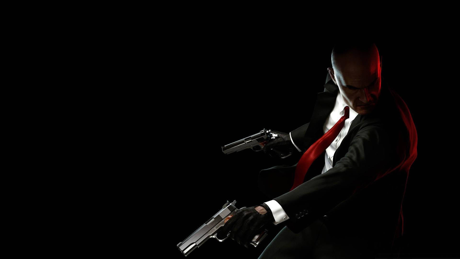 Hitman Absolution 桌布 壁紙 — 一個光頭男子身穿黑色西裝和紅色領帶，在黑暗背景中手持兩把手槍，伴隨戲劇性的紅色燈光。