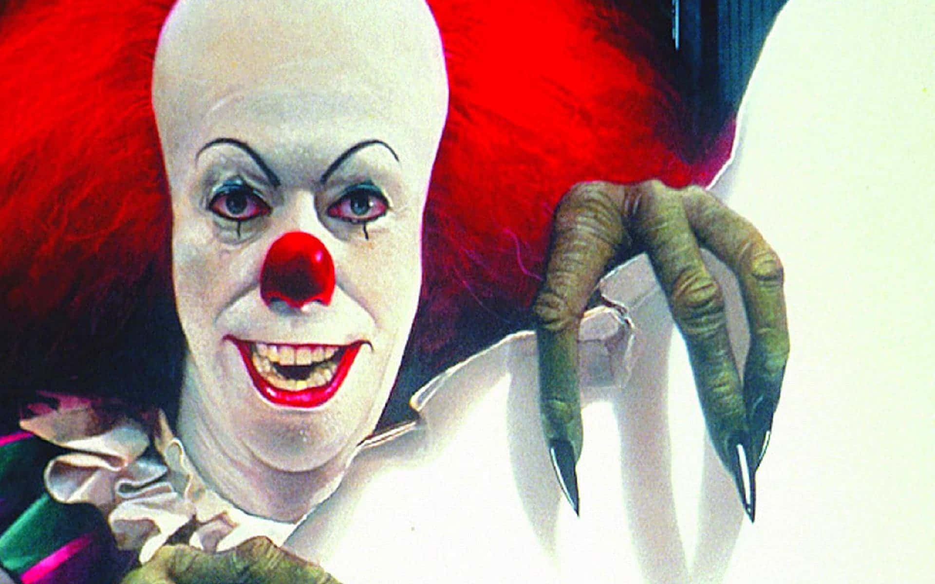 Tim Curry 桌布 壁紙 — 一個光頭紅髮、利爪的威脅小丑，帶著邪惡的笑容從破牆中窺視。
