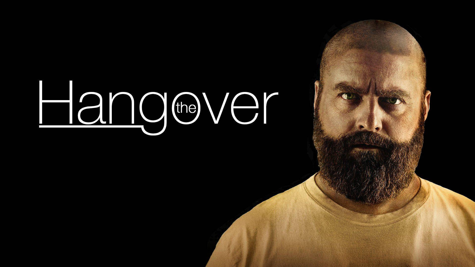 the hangover 桌布 壁紙 — 一個光頭鬍鬚男人穿著黃色襯衫，在黑色背景上以白色文字寫著「Hangover」，眼神強烈地凝視。