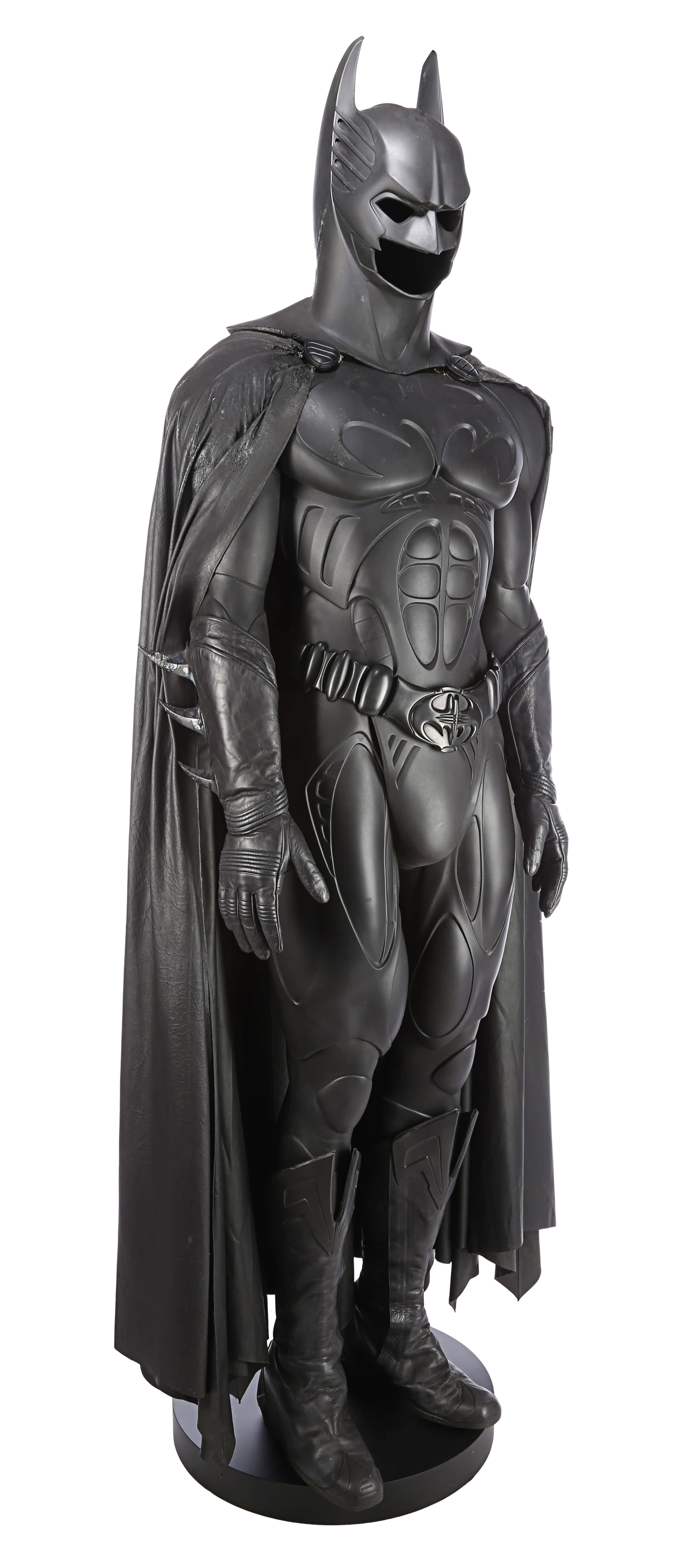 Bat-suit 桌布 壁紙 — 一個全身蝙蝠俠雕像，身穿時尚黑色裝甲服，披風飄逸，站立在基座上。