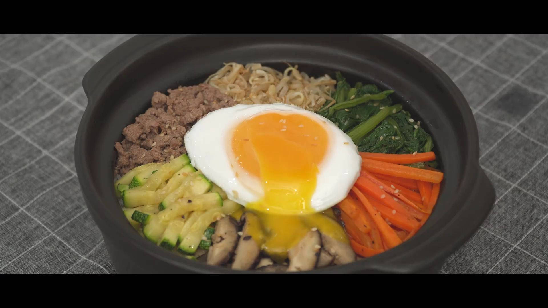 烹飪 桌布 壁紙 — 一個冒煙的石鍋拌飯，上面放著一個完美流心的太陽蛋。