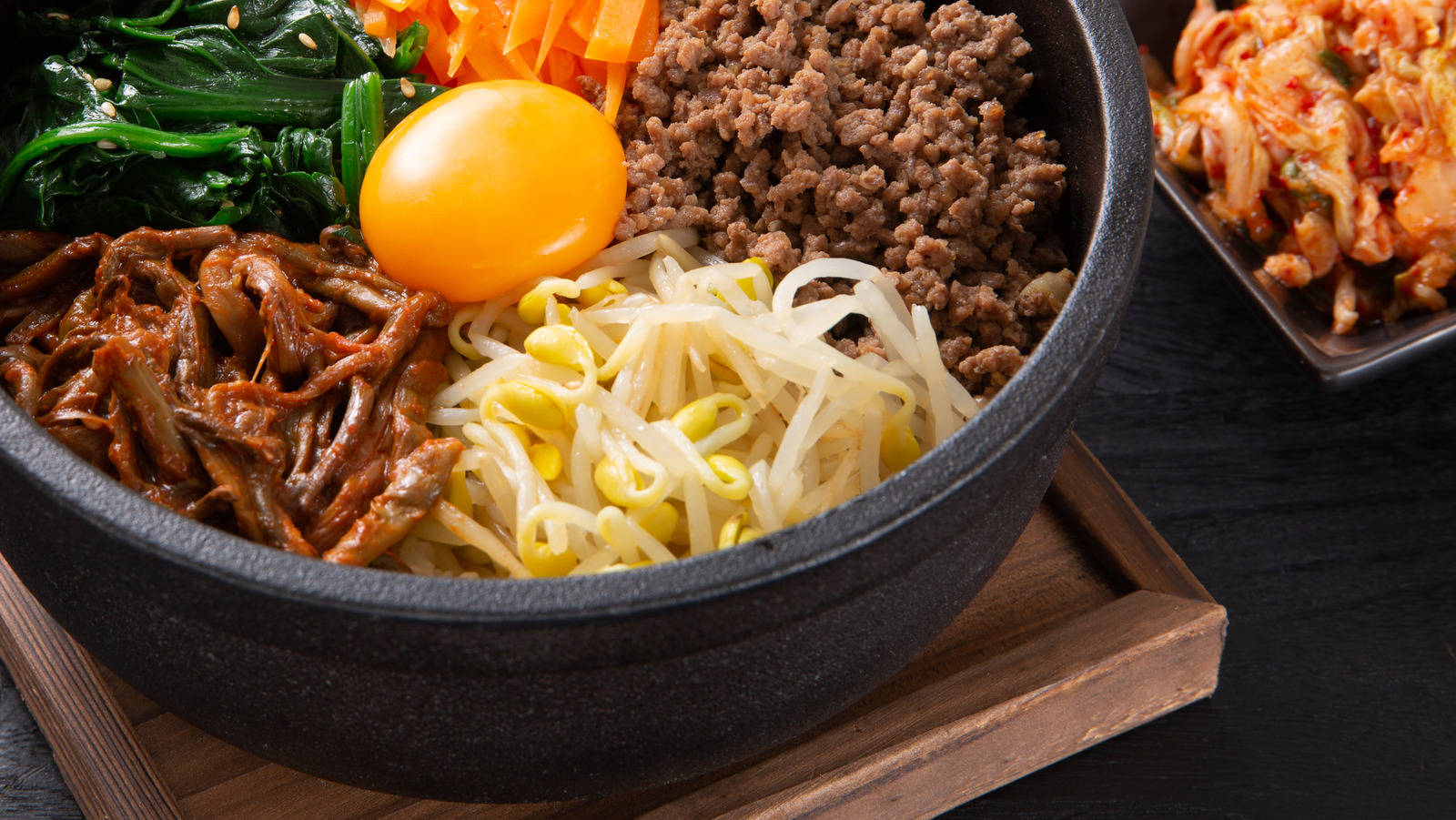 烹飪 桌布 壁紙 — 一個冒煙的石鍋韓國拌飯，上面放有生雞蛋、豆芽、牛肉和菠菜，旁邊有泡菜。