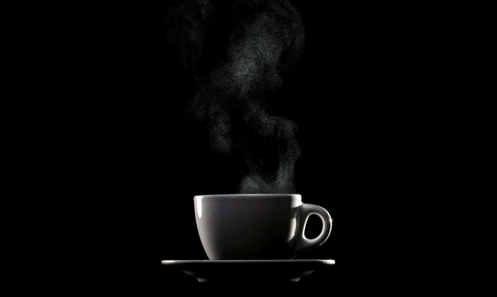 Black Coffee 桌布 壁紙 — 一個冒著蒸氣的白咖啡杯放在碟子上，在純黑背景下柔和發光。