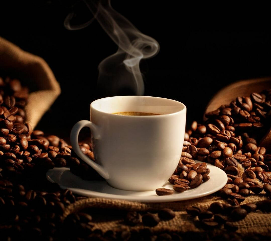 冒著蒸氣的咖啡杯，被粗麻布上的烘焙豆環繞。 — 咖啡動圖 壁紙