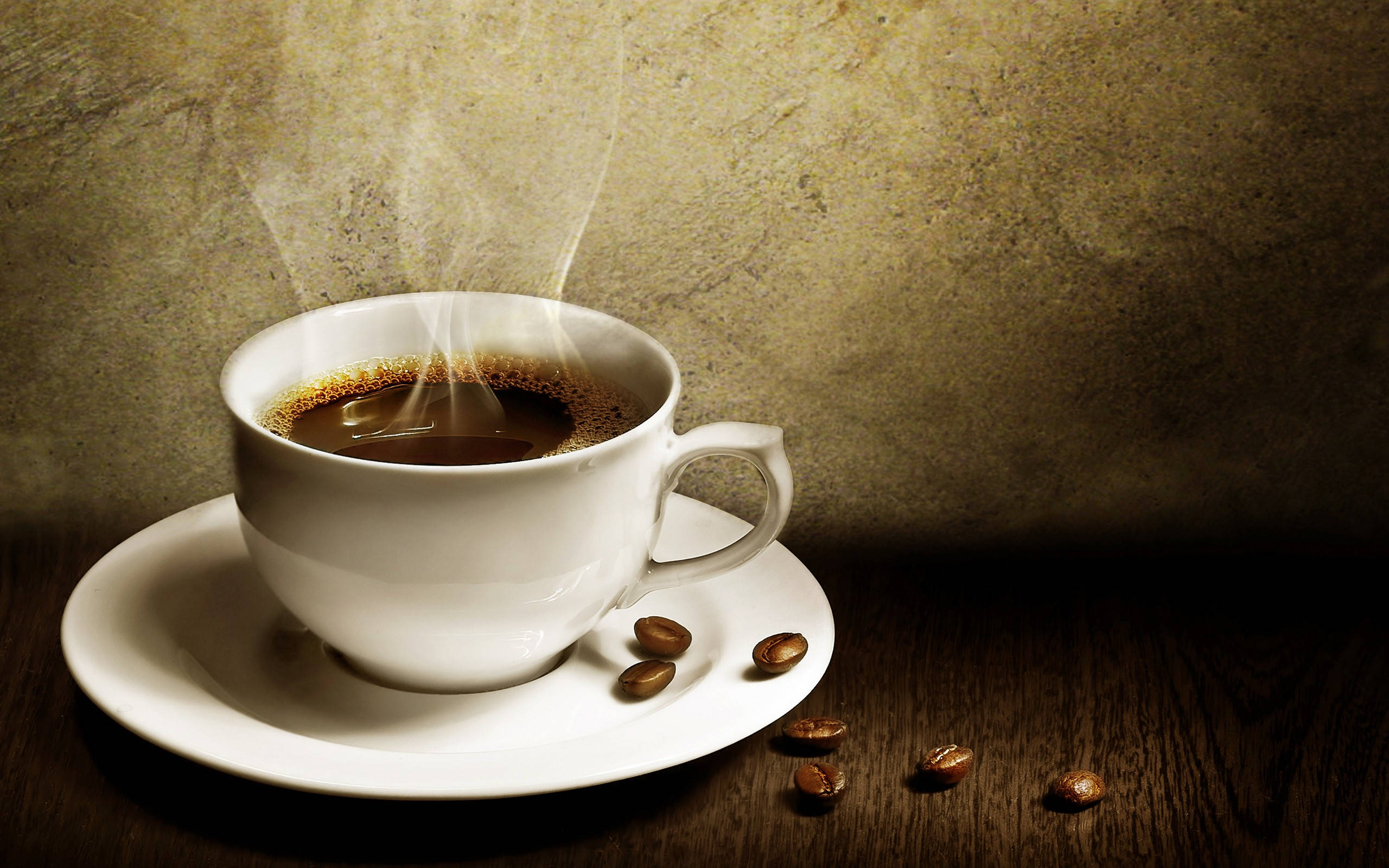 Coffee Aesthetic 桌布 壁紙 — 一個冒著蒸氣的白咖啡杯放在碟子上，深色木質表面上散落著咖啡豆，背景是帶紋理的米色牆壁。