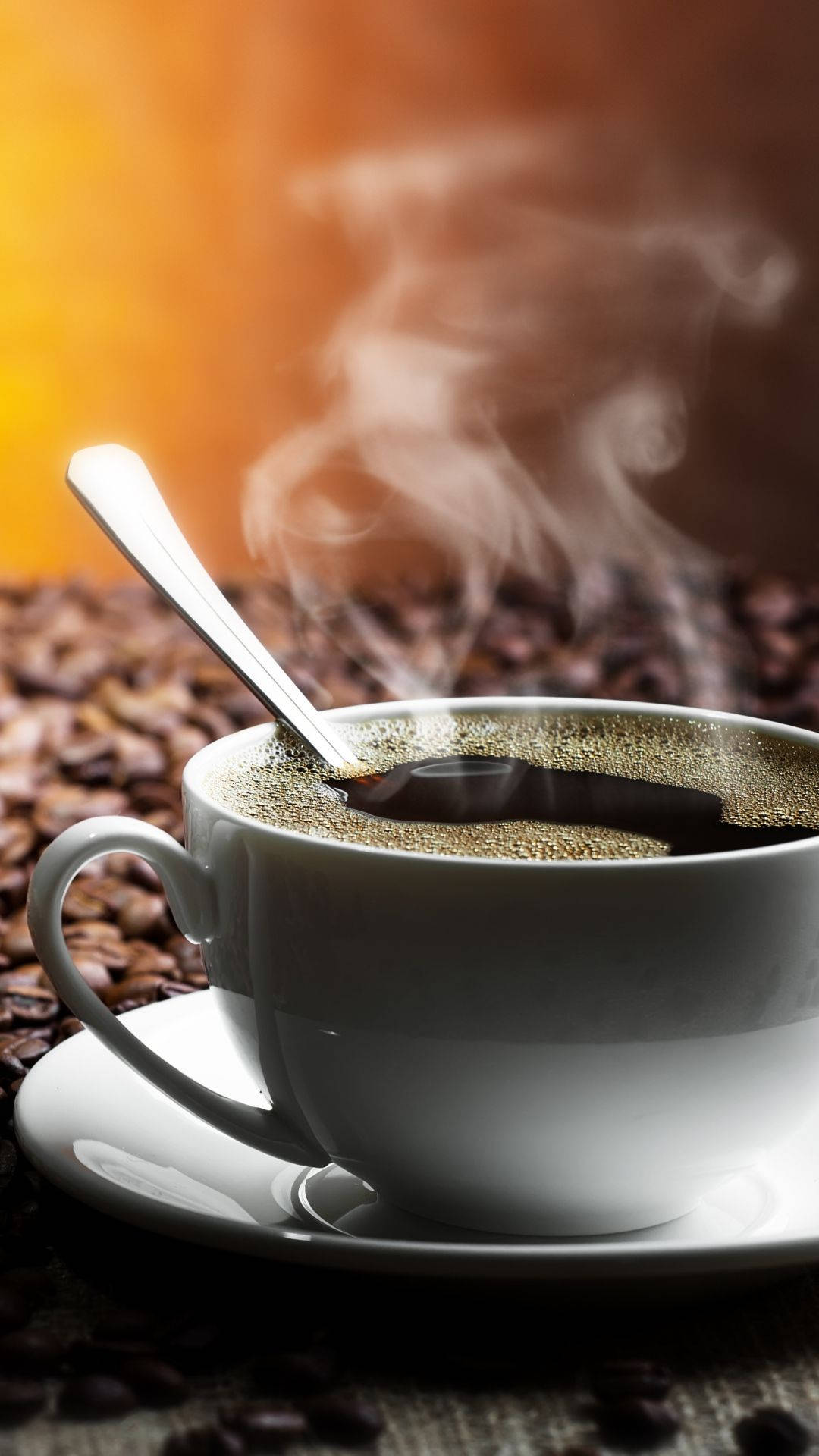 cup 桌布 壁紙 — 一個冒著蒸氣的白色咖啡杯連湯匙放在碟子上，周圍是深烘焙咖啡豆，背景是溫暖的橙色漸變。