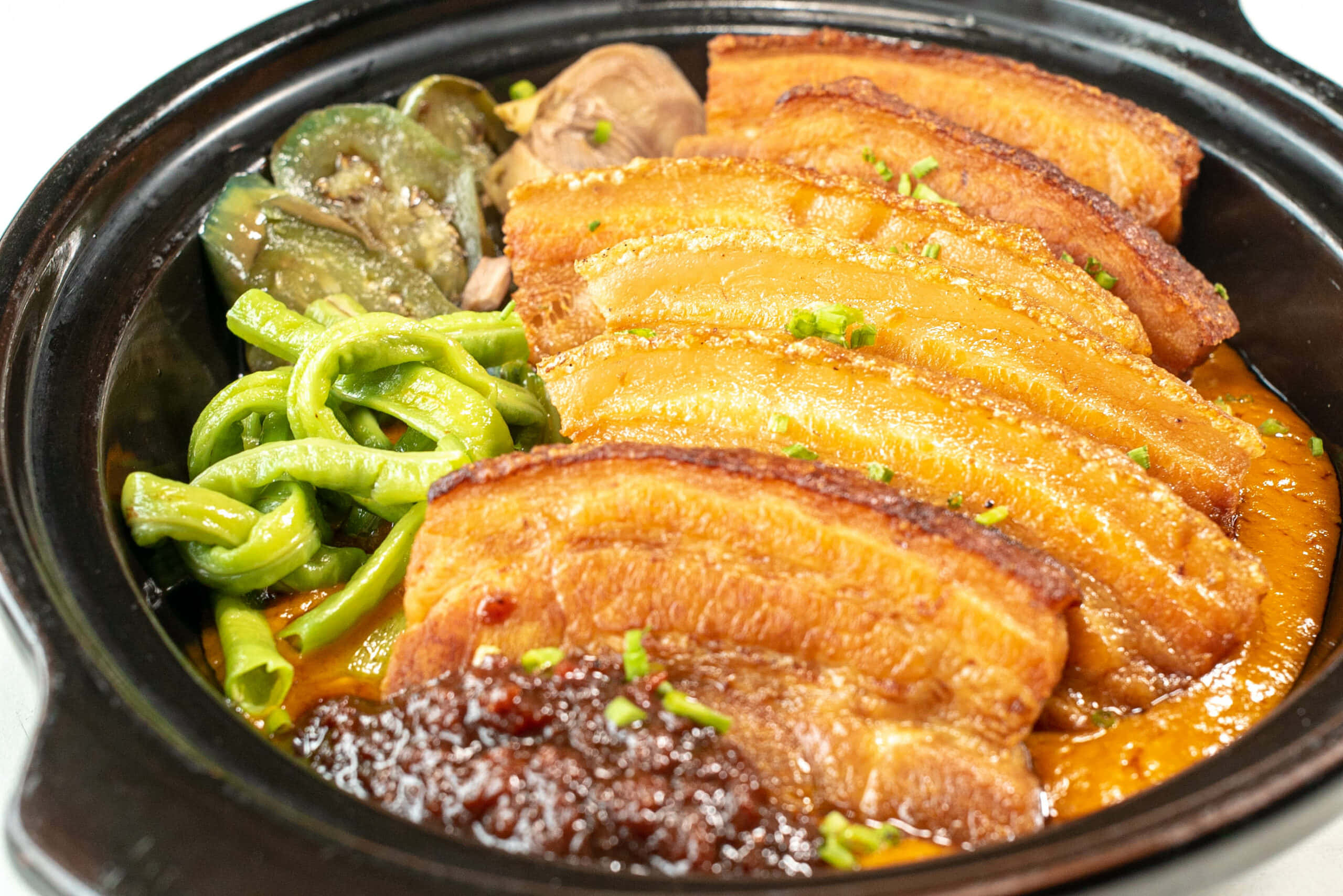 meat 桌布 壁紙 — 一個冒著蒸氣的砂鍋，裡面裝滿了油亮的紅燒五花肉、青椒和美味的醬汁，上面撒上切碎的青蔥。