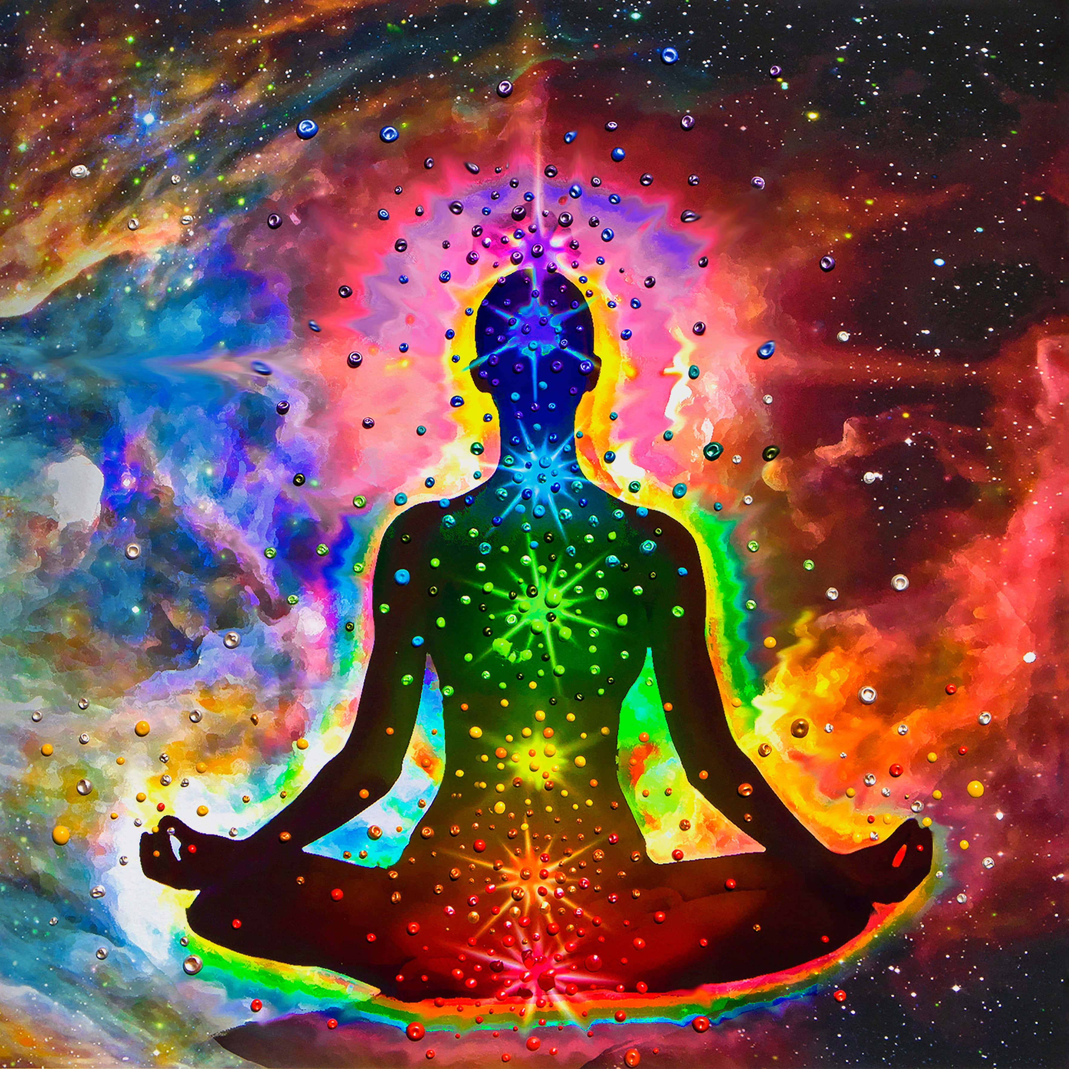 靈性動圖 桌布 壁紙 — 一個冥想的人類剪影在宇宙星雲背景下散發出色彩繽紛的脈輪，並有閃爍的星星。