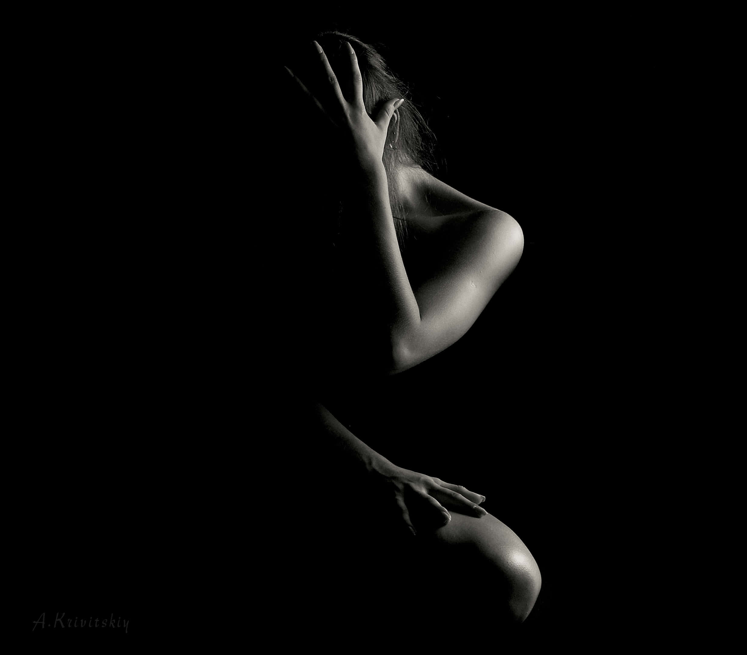 Silhouette 桌布 壁紙 — 一個剪影中的女人在黑暗中蹲下，一隻手遮住臉，另一隻手放在膝蓋上。